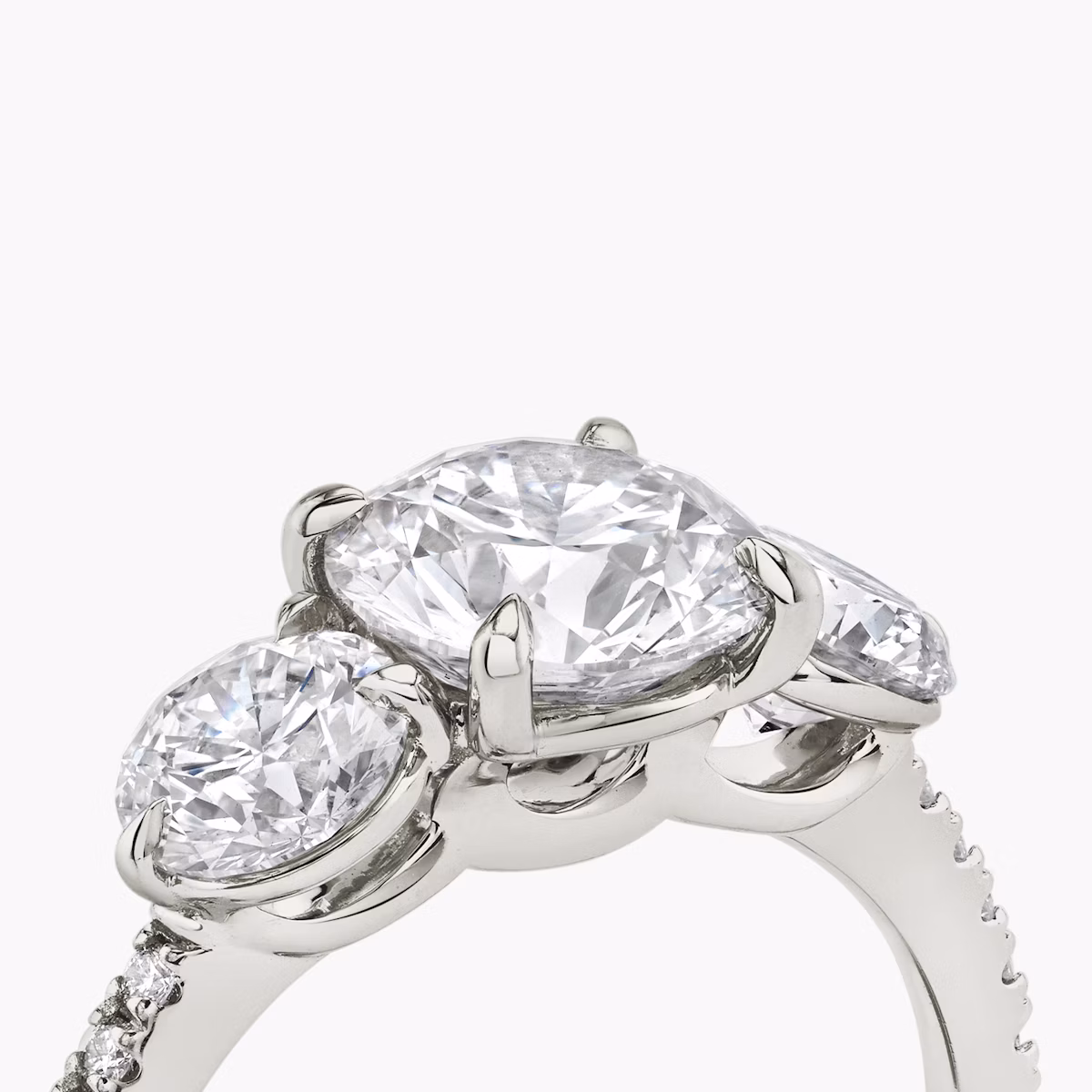 The Three Stone | Round Brilliant | Platinum | bandAccent: Pavé | caratWeight: other | sideStoneCarat: 0.50ct | sideStoneShape: Round Brilliant | diamondOrientation: vertical