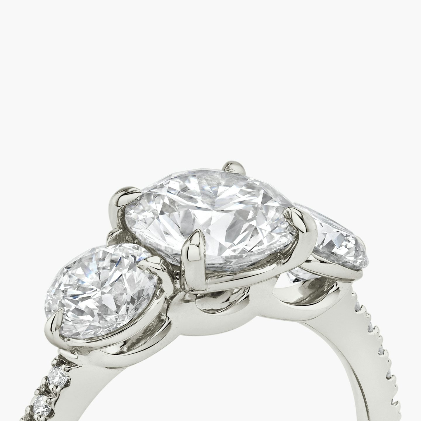 The Three Stone | Round Brilliant | Platinum | bandAccent: Pavé | caratWeight: other | sideStoneCarat: 0.50ct | sideStoneShape: Round Brilliant | diamondOrientation: vertical