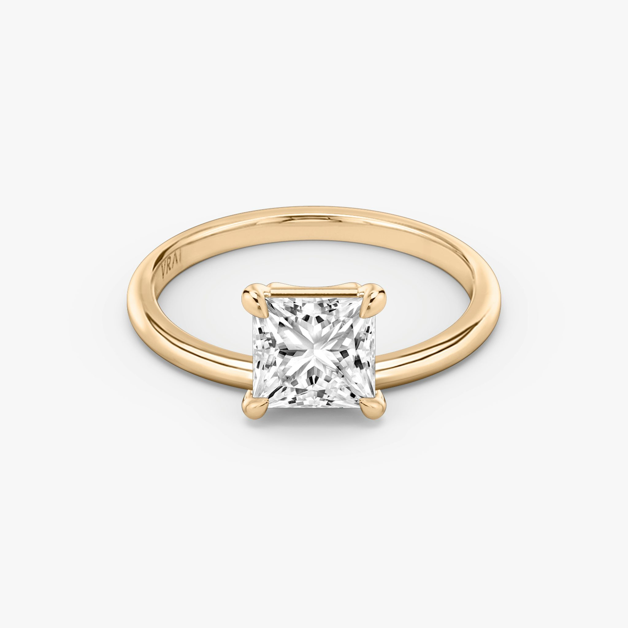 A gold engagement ring with one square diamond.