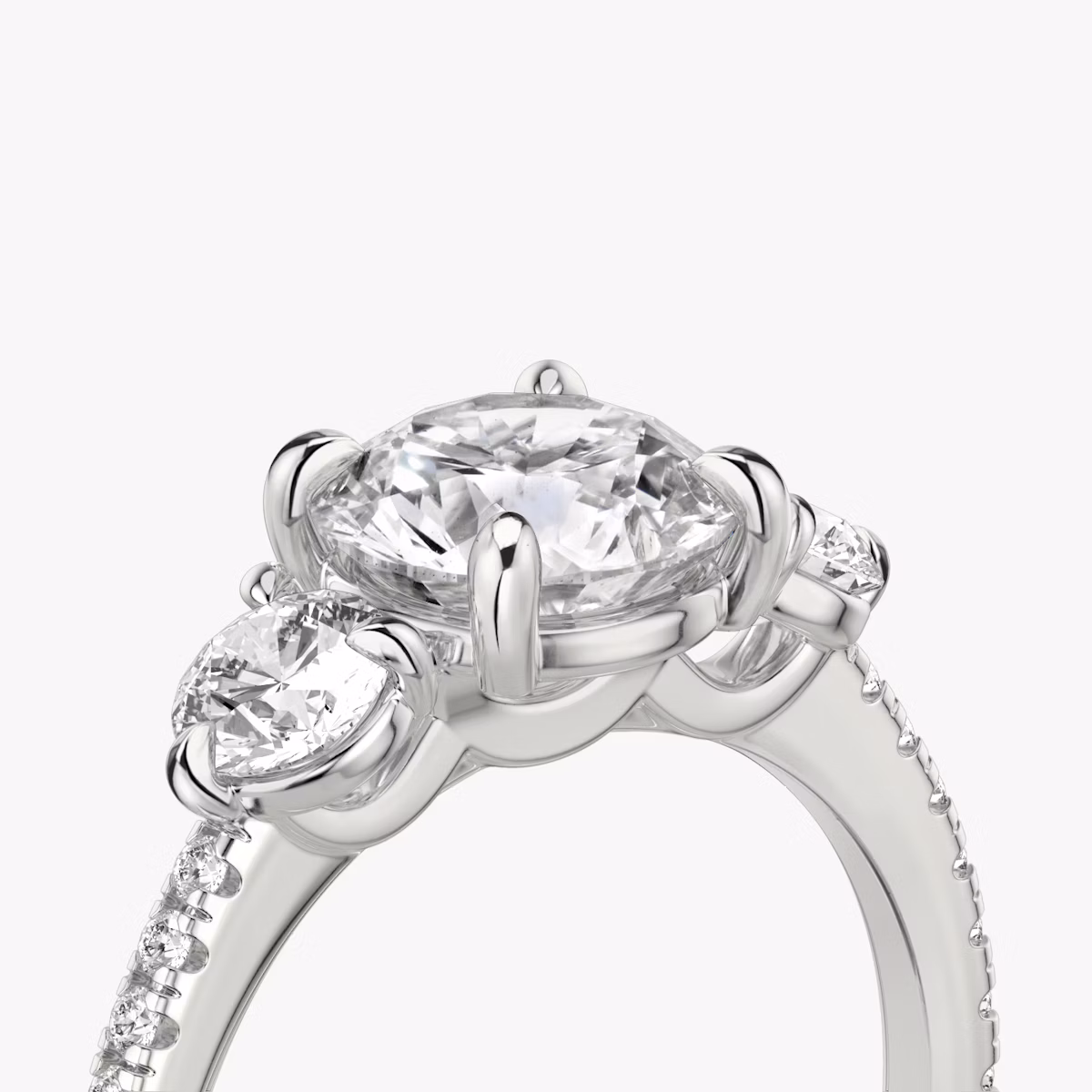 The Three Stone | Round Brilliant | Platinum | bandAccent: Pavé | caratWeight: other | sideStoneCarat: 0.25ct | sideStoneShape: Round Brilliant | diamondOrientation: vertical