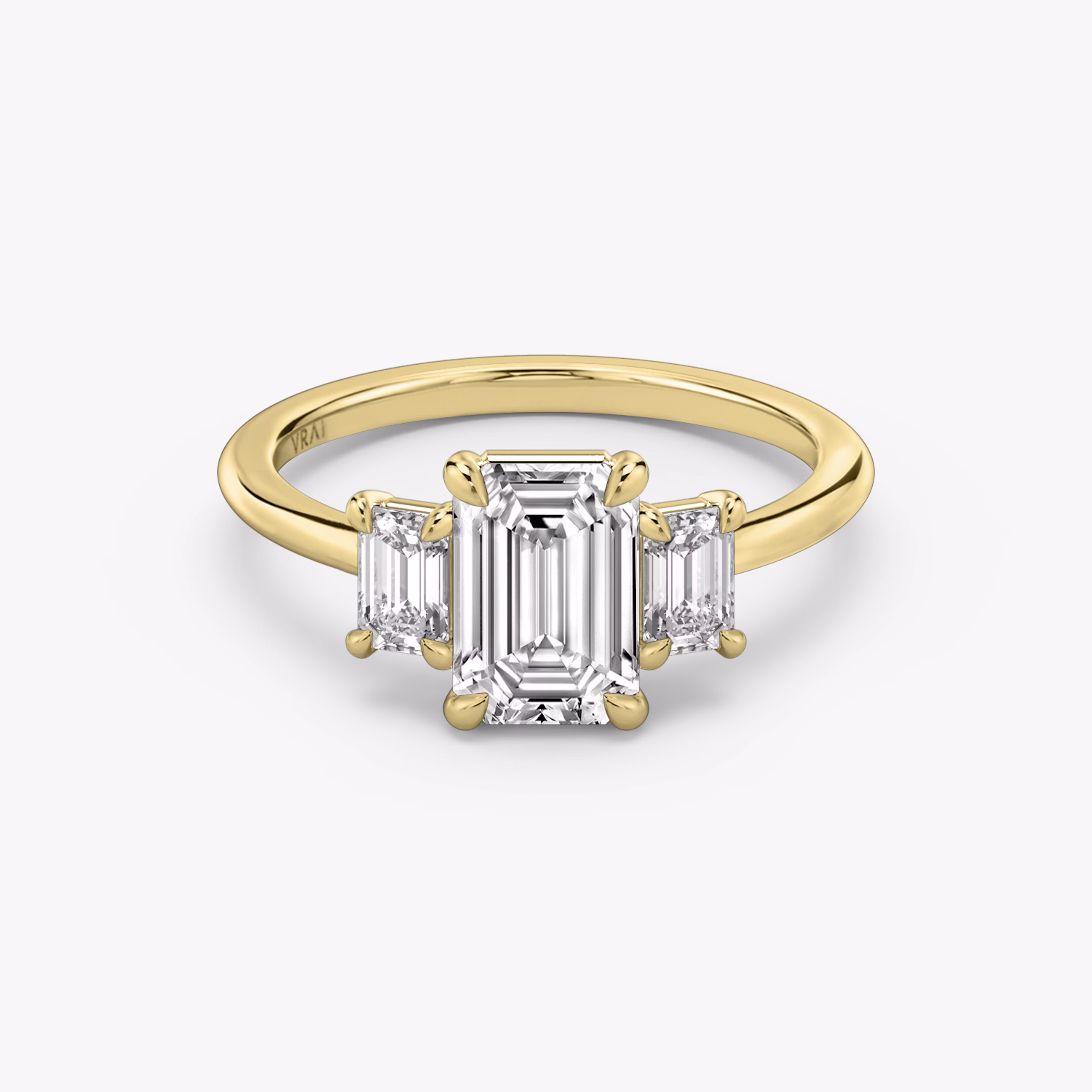 three stone emerald cut engagement ring with yellow band