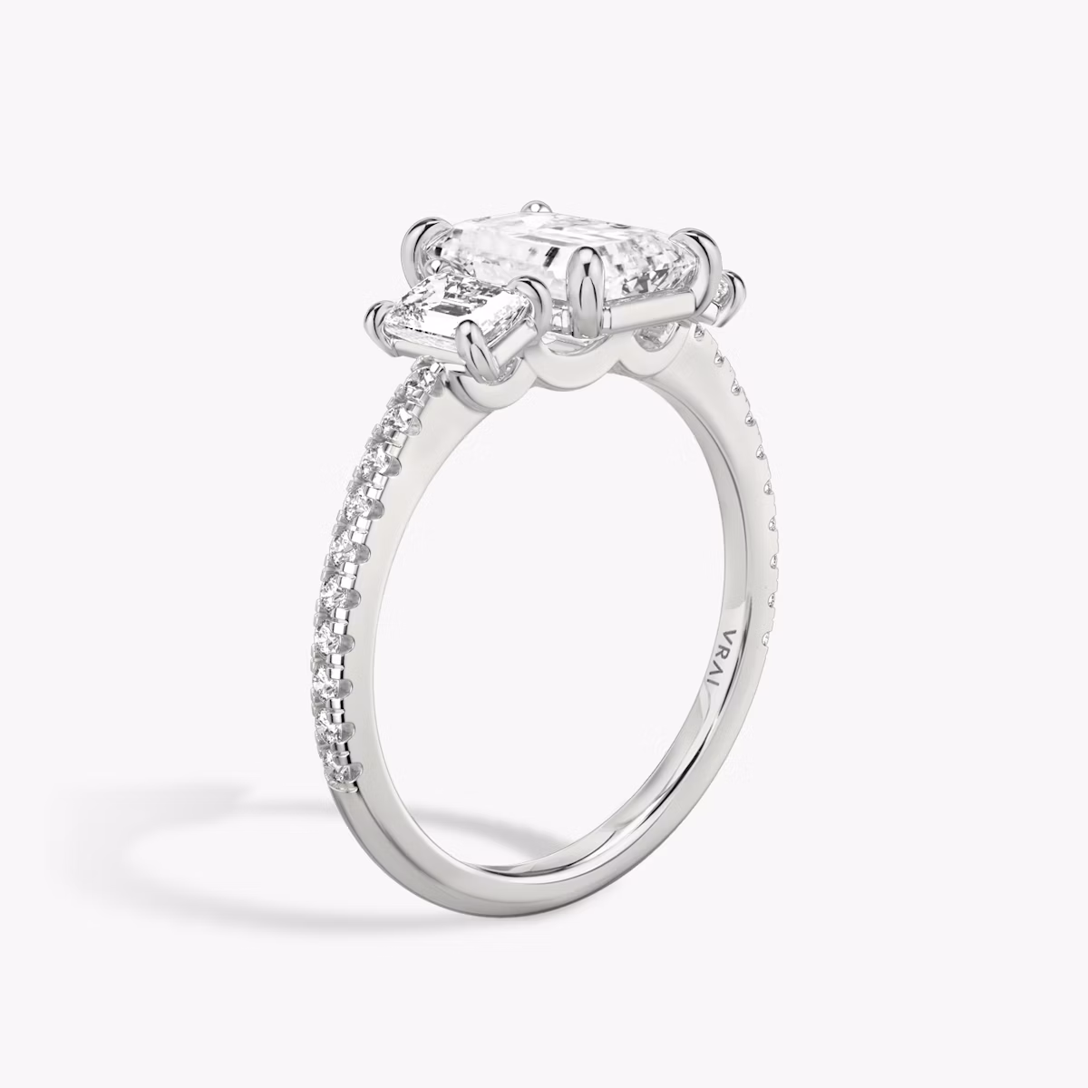 The Three Stone | Emerald | Platinum | bandAccent: Pavé | sideStoneCarat: 0.25ct | sideStoneShape: Emerald | diamondOrientation: vertical | caratWeight: other