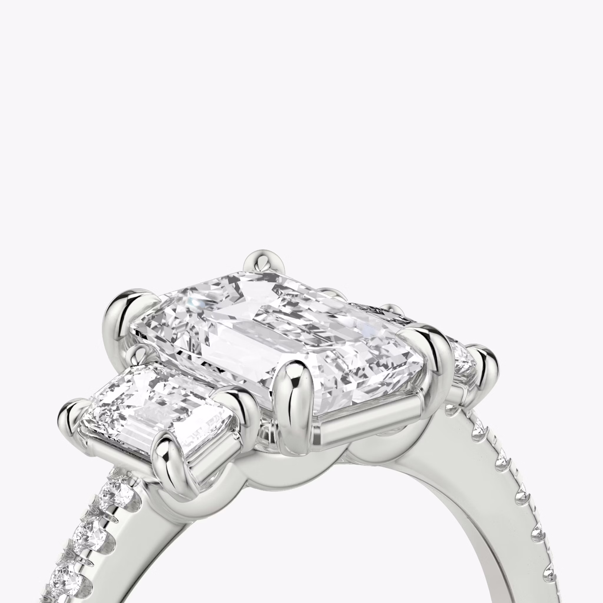 The Three Stone | Emerald | Platinum | bandAccent: Pavé | sideStoneCarat: 0.25ct | sideStoneShape: Emerald | diamondOrientation: vertical | caratWeight: other