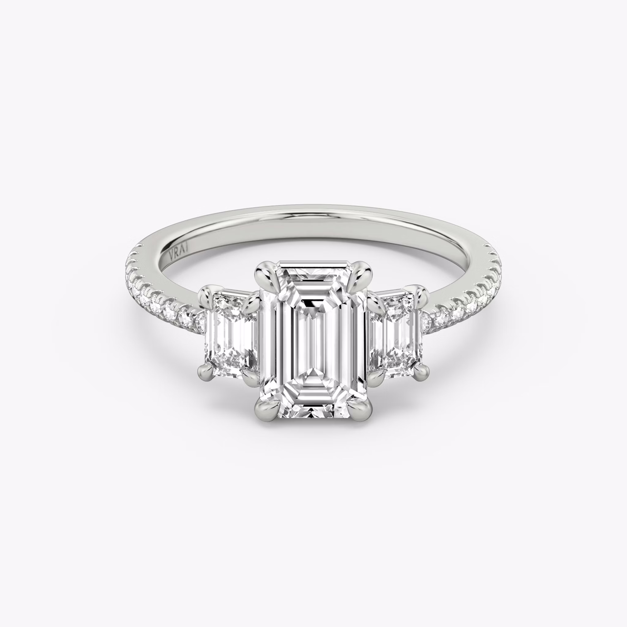 The Three Stone | Emerald | Platinum | bandAccent: Pavé | sideStoneCarat: 0.25ct | sideStoneShape: Emerald | diamondOrientation: vertical | caratWeight: other
