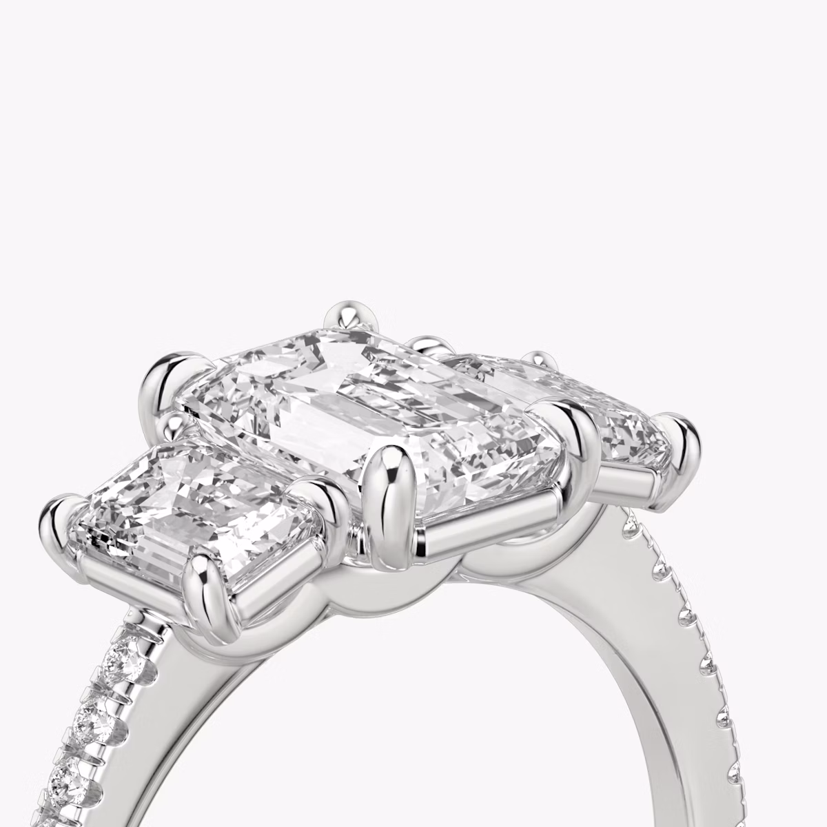 The Three Stone | Emerald | Platinum | bandAccent: Pavé | sideStoneCarat: 0.50ct | sideStoneShape: Emerald | diamondOrientation: vertical | caratWeight: other