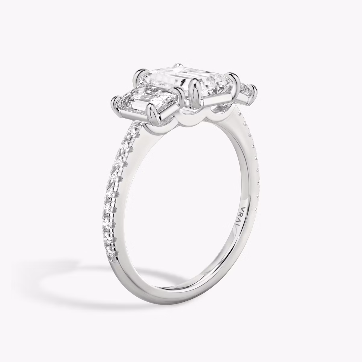 The Three Stone | Emerald | Platinum | bandAccent: Pavé | sideStoneCarat: 0.50ct | sideStoneShape: Emerald | diamondOrientation: vertical | caratWeight: other