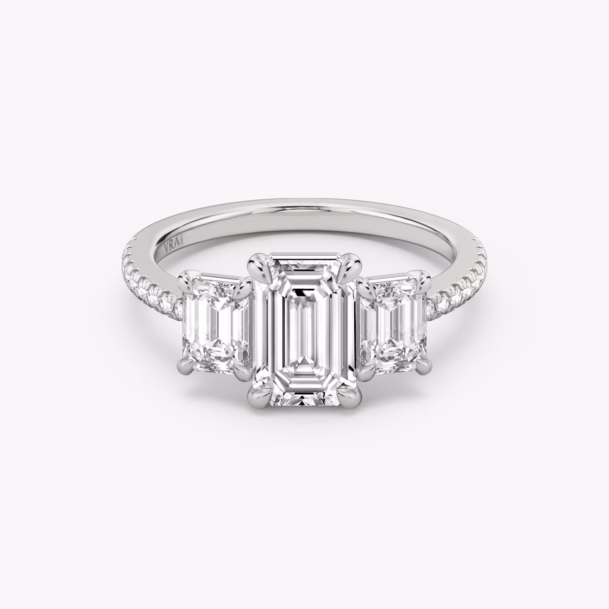 The Three Stone | Emerald | Platinum | bandAccent: Pavé | sideStoneCarat: 0.50ct | sideStoneShape: Emerald | diamondOrientation: vertical | caratWeight: other
