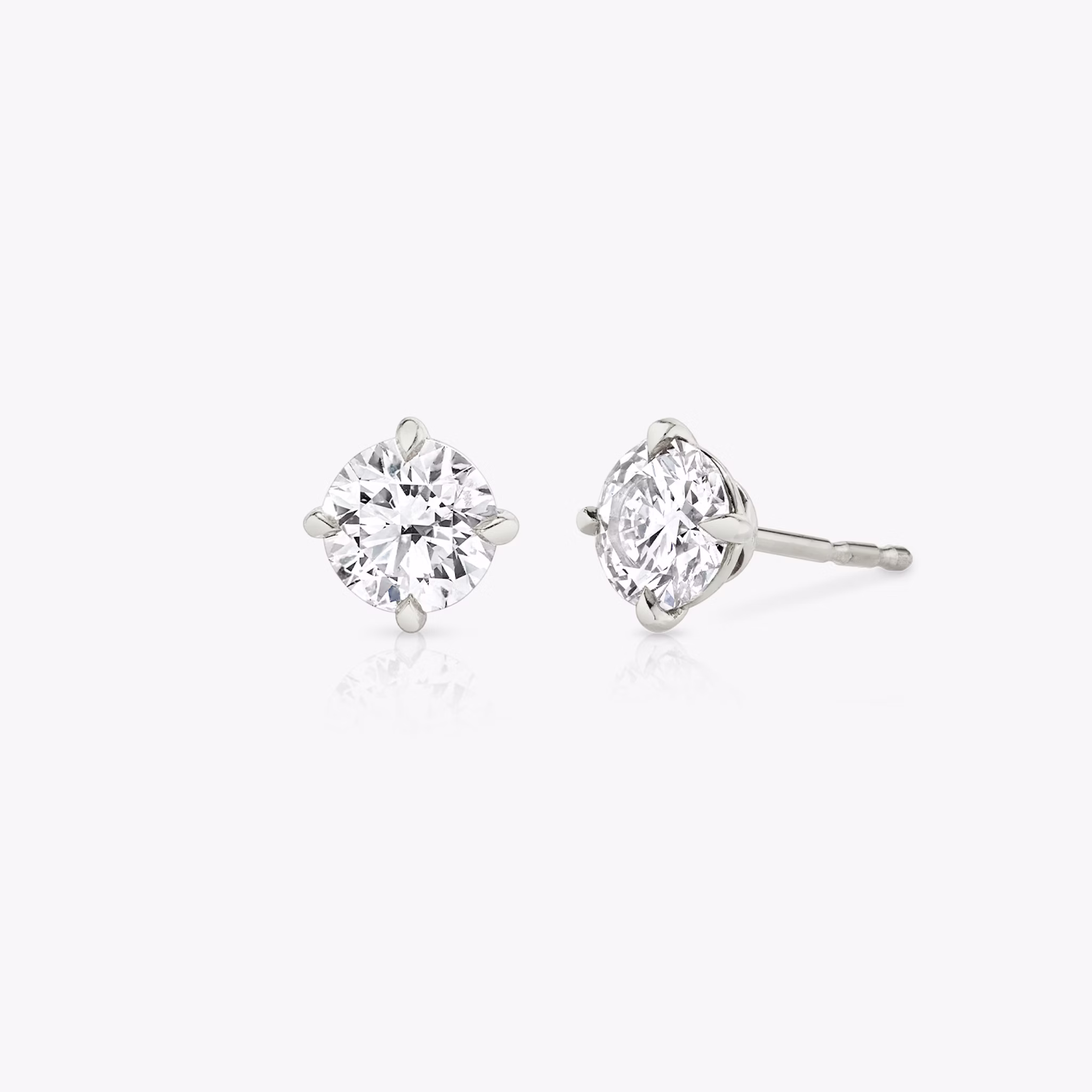 solitaire round stud earrings in white gold with three-quarter view for fine jewelry product display.