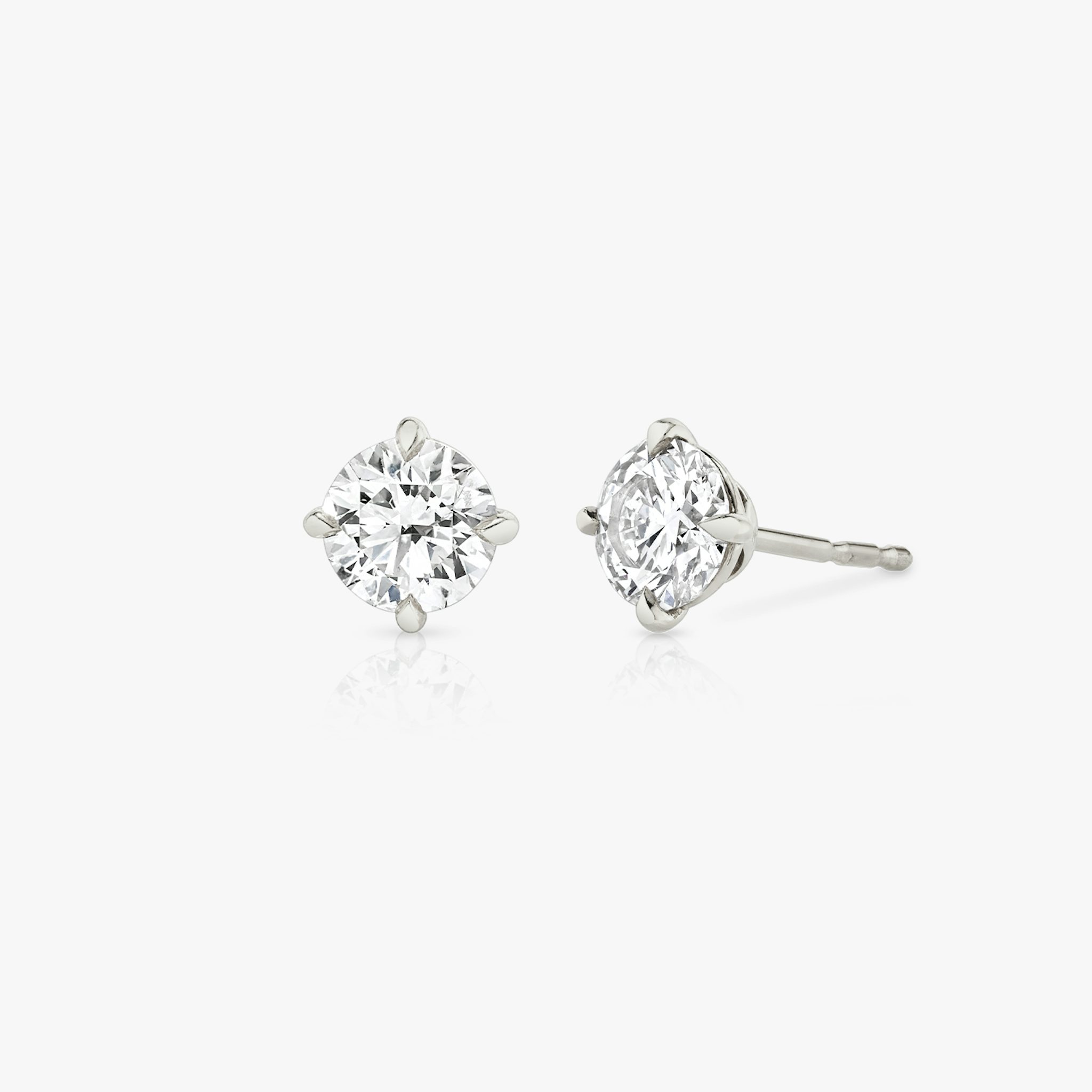 solitaire round stud earrings in white gold with three-quarter view for fine jewelry product display.