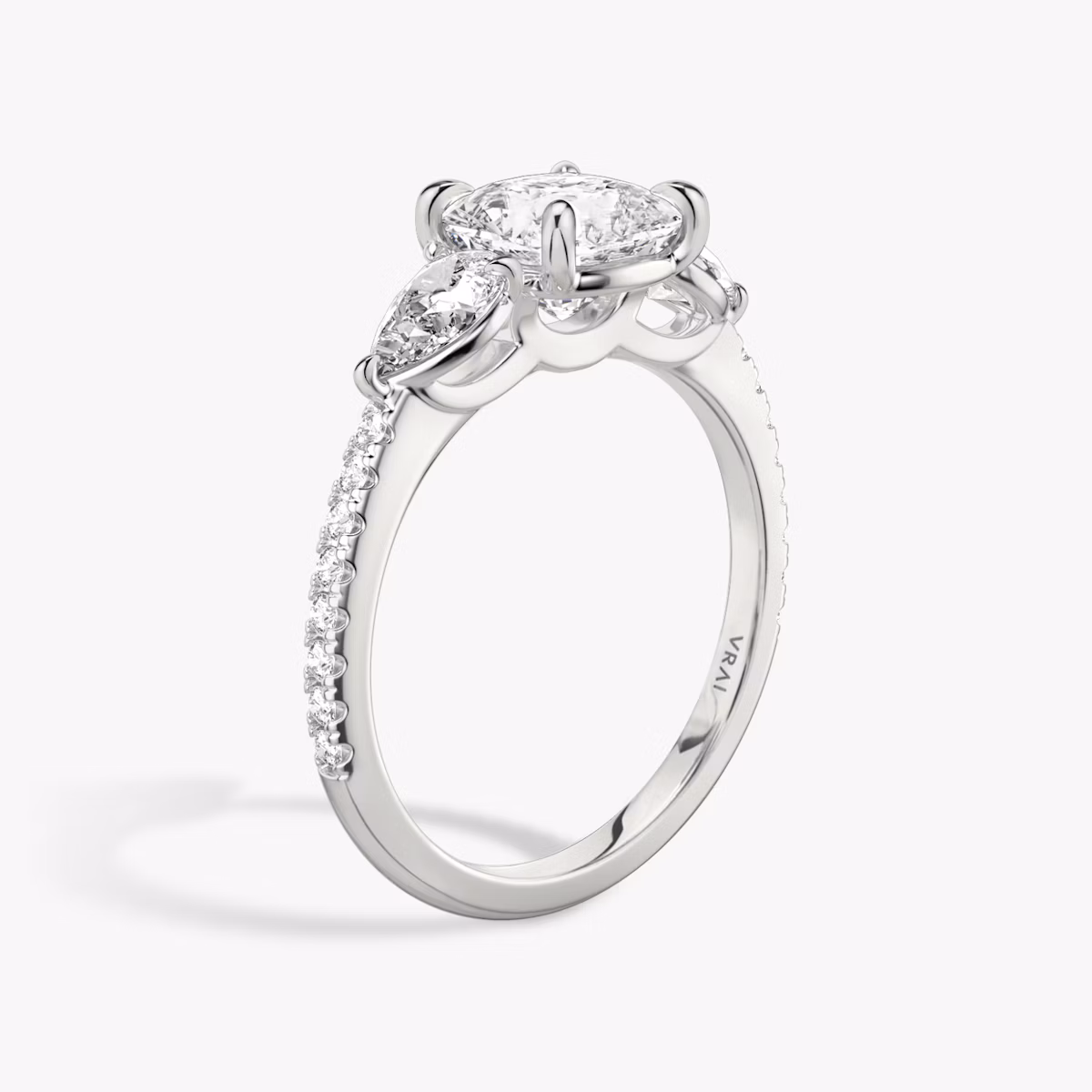 The Three Stone | Cushion | Platinum | bandAccent: Pavé | sideStoneCarat: 0.25ct | sideStoneShape: Pear | diamondOrientation: vertical | caratWeight: other