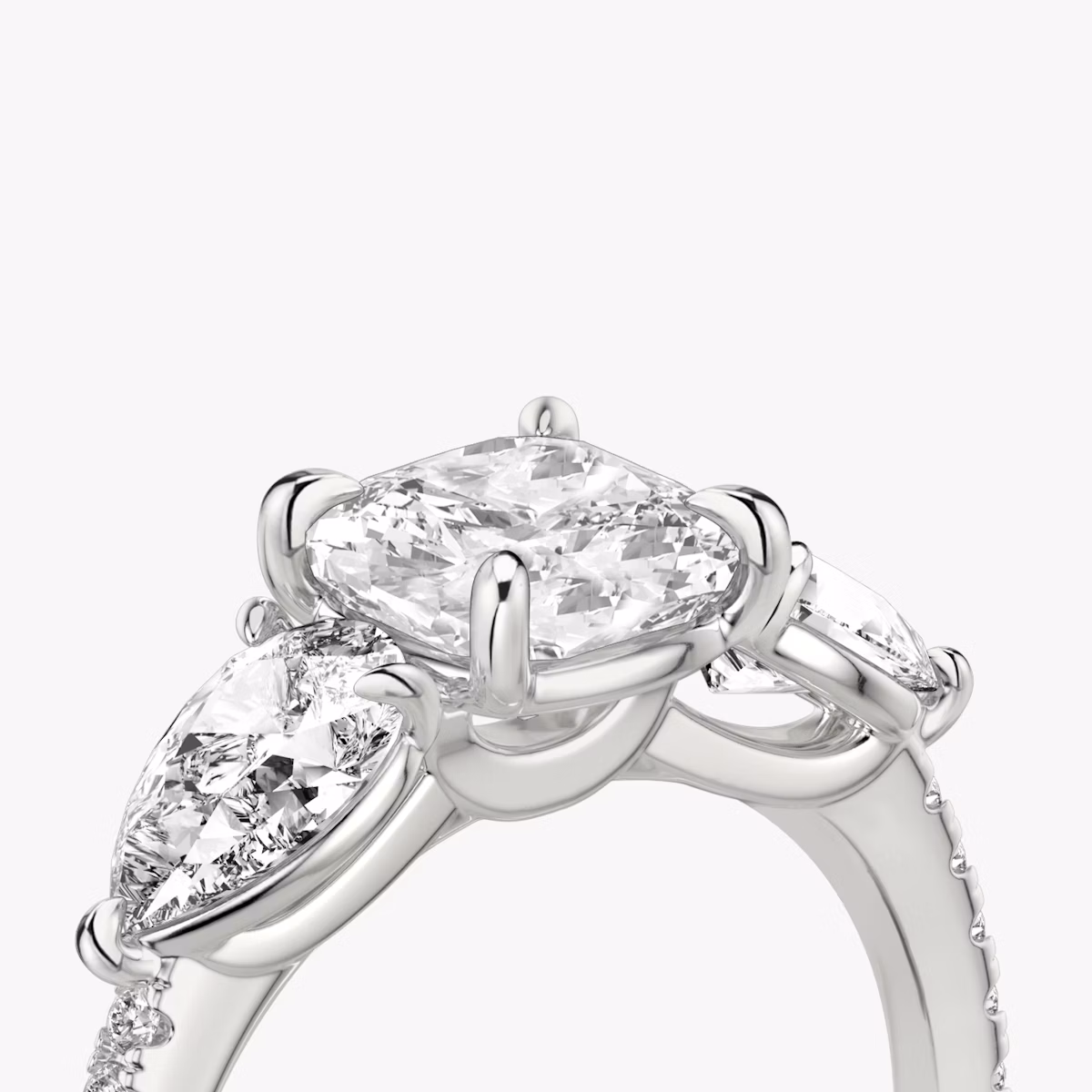 The Three Stone | Cushion | Platinum | bandAccent: Pavé | sideStoneCarat: 0.50ct | sideStoneShape: Pear | diamondOrientation: vertical | caratWeight: other