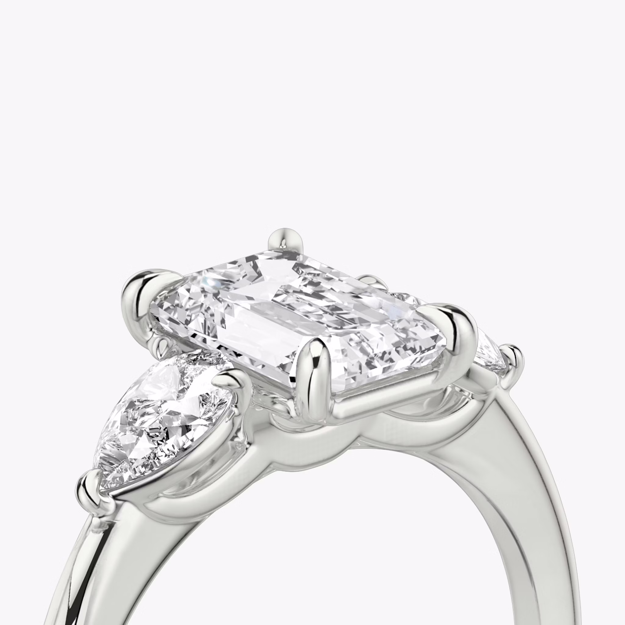 Three Stone | Emerald | Platin | bandAccent: Ohne Pavé-Besatz | sideStoneCarat: 0.25ct | sideStoneShape: Tropfen | diamondOrientation: vertical | caratWeight: other