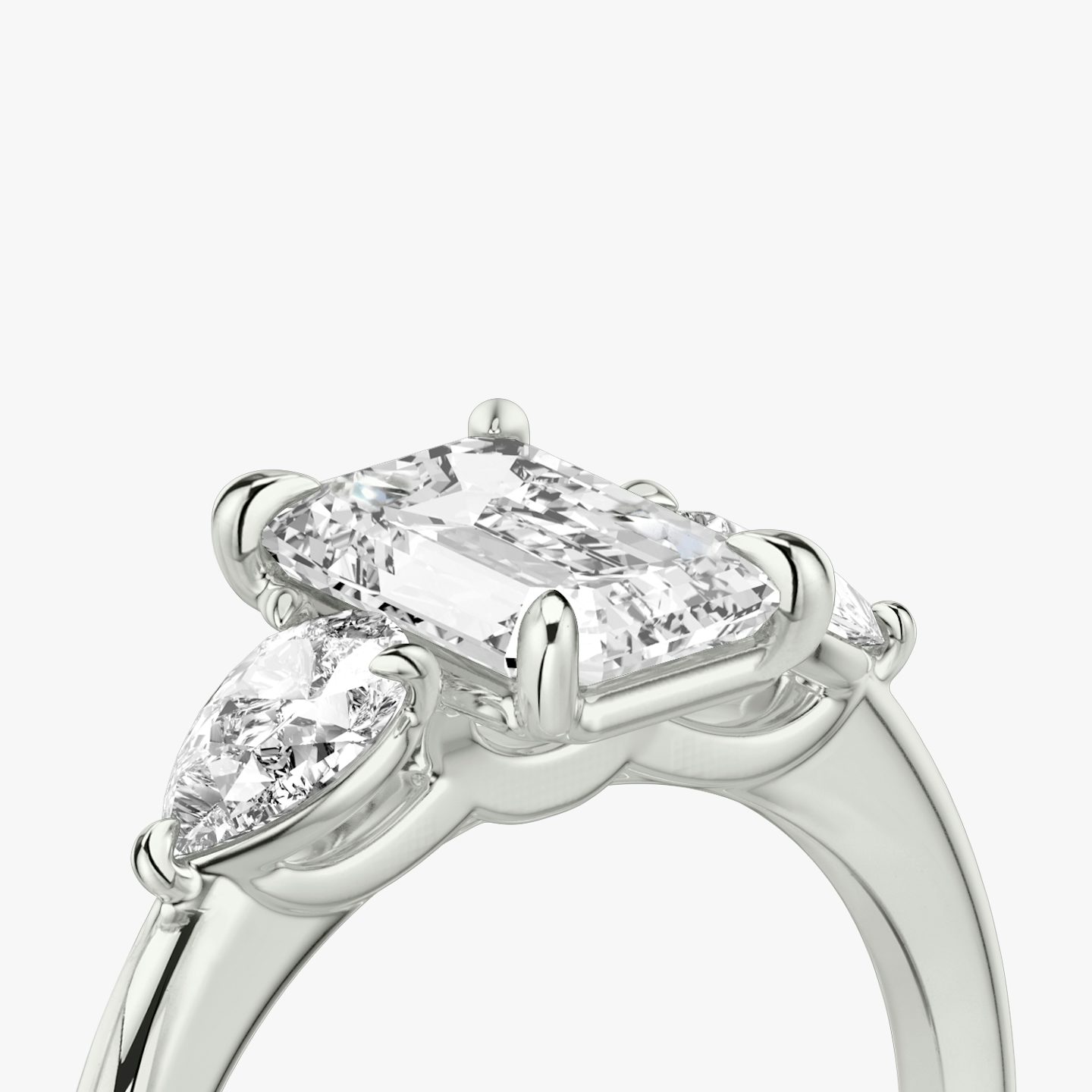 The Three Stone | Emerald | Platinum | bandAccent: Plain | sideStoneCarat: 0.25ct | sideStoneShape: Pear | diamondOrientation: vertical | caratWeight: other