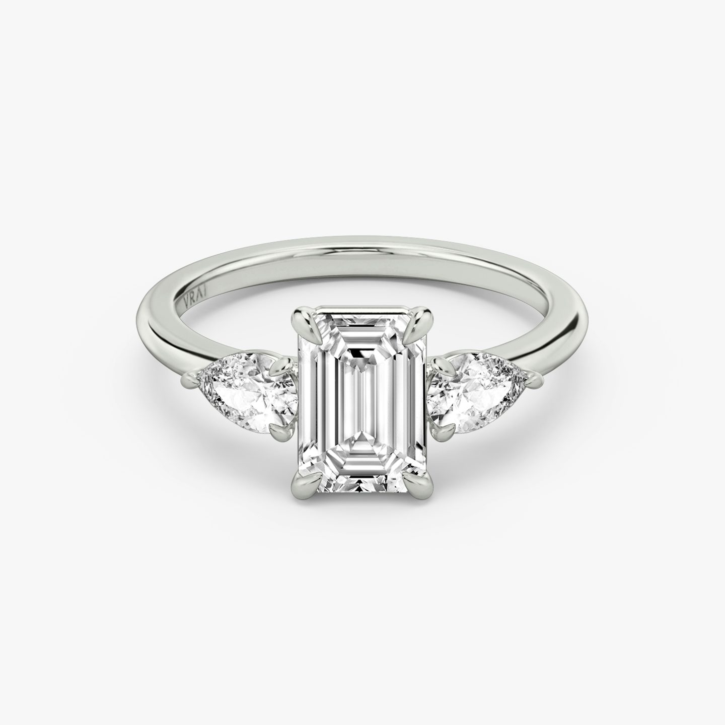 The Three Stone | Emerald | Platinum | bandAccent: Plain | sideStoneCarat: 0.25ct | sideStoneShape: Pear | diamondOrientation: vertical | caratWeight: other