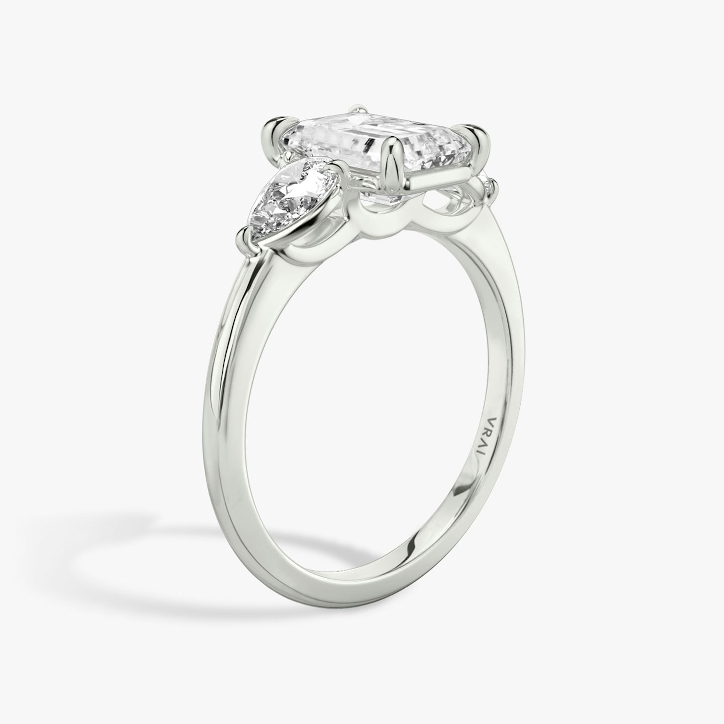 The Three Stone | Emerald | Platinum | bandAccent: Plain | sideStoneCarat: 0.25ct | sideStoneShape: Pear | diamondOrientation: vertical | caratWeight: other