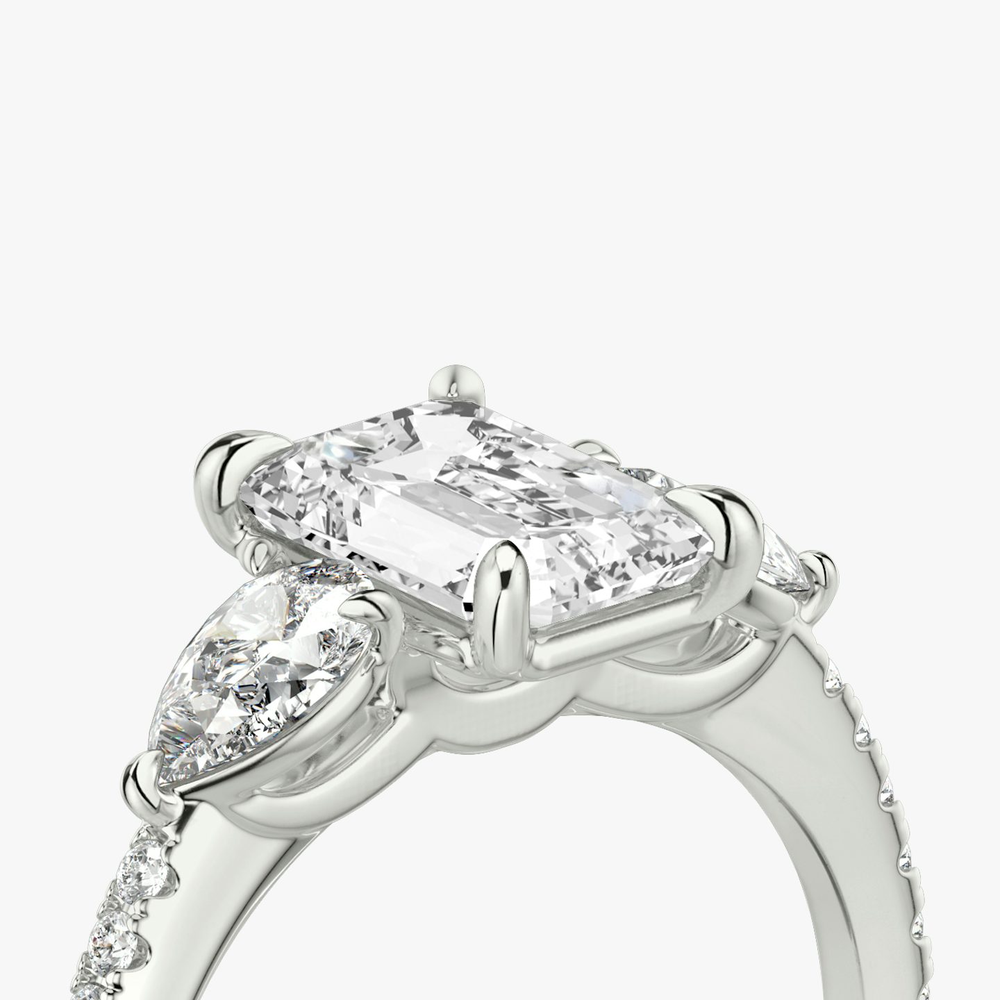 The Three Stone | Emerald | Platinum | bandAccent: Pavé | sideStoneCarat: 0.25ct | sideStoneShape: Pear | diamondOrientation: vertical | caratWeight: other