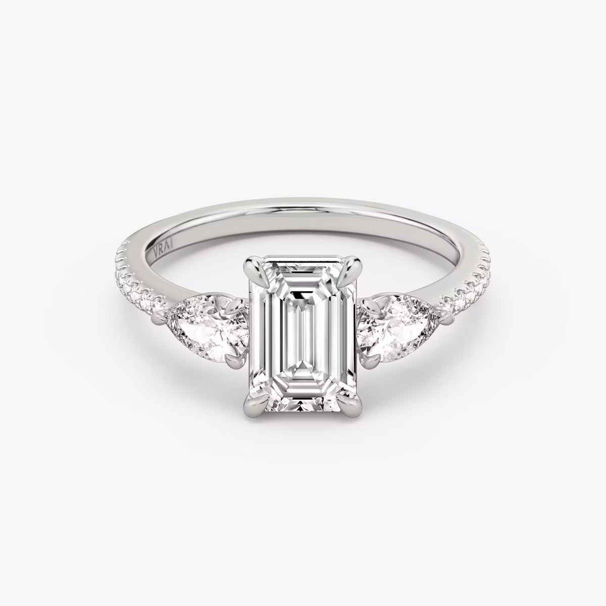 The Three Stone | Emerald | Platinum | bandAccent: Pavé | sideStoneCarat: 0.25ct | sideStoneShape: Pear | diamondOrientation: vertical | caratWeight: other