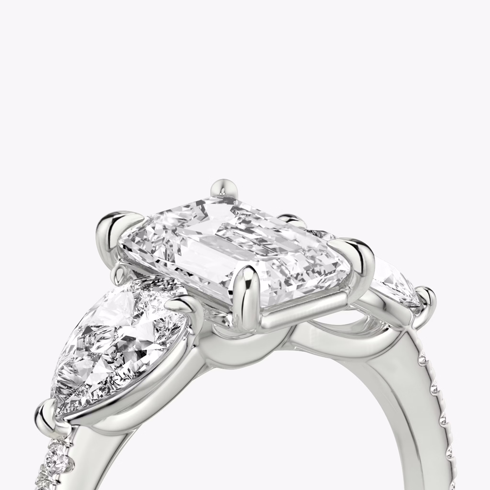 The Three Stone | Emerald | Platinum | bandAccent: Pavé | sideStoneCarat: 0.50ct | sideStoneShape: Pear | diamondOrientation: vertical | caratWeight: other