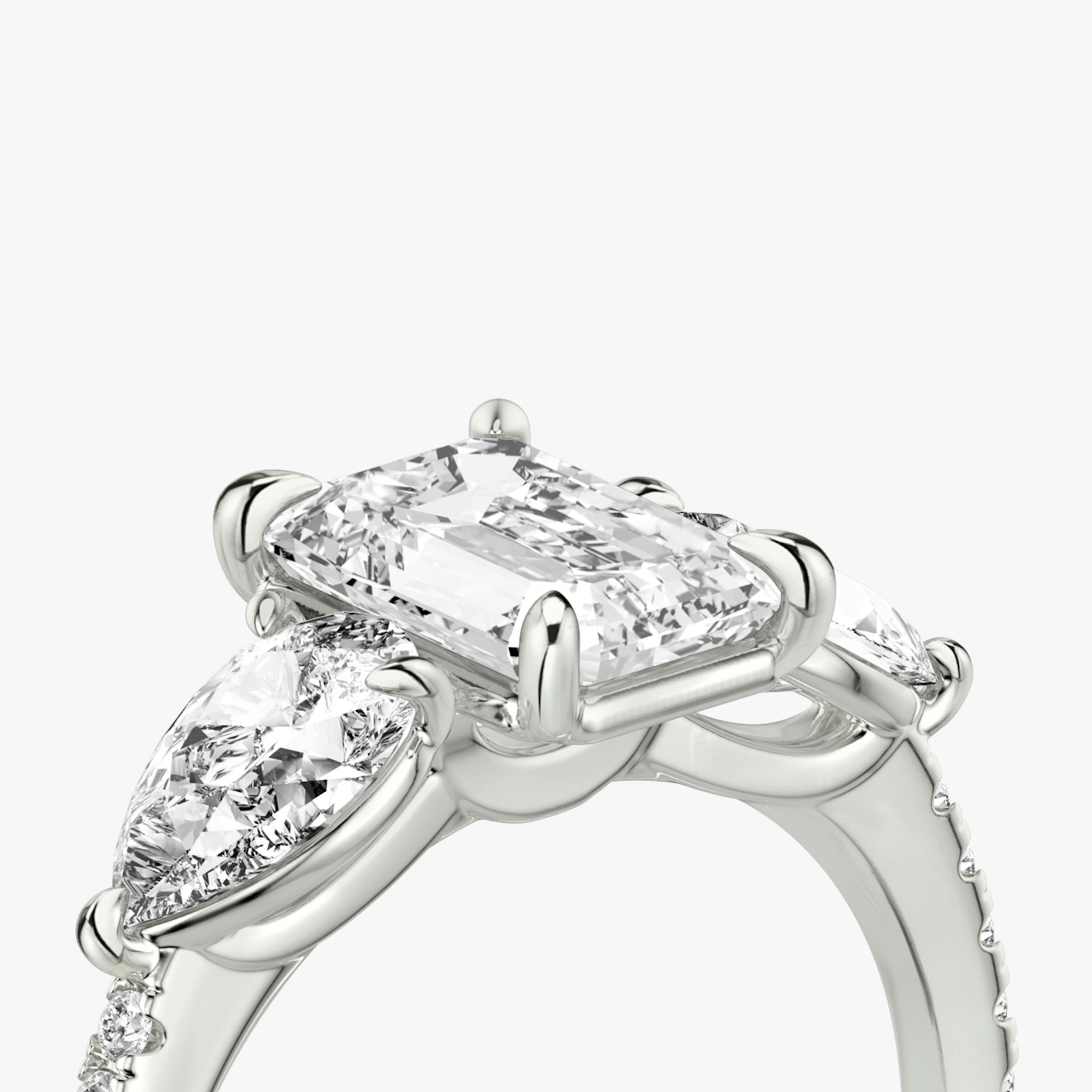 The Three Stone | Emerald | Platinum | bandAccent: Pavé | sideStoneCarat: 0.50ct | sideStoneShape: Pear | diamondOrientation: vertical | caratWeight: other