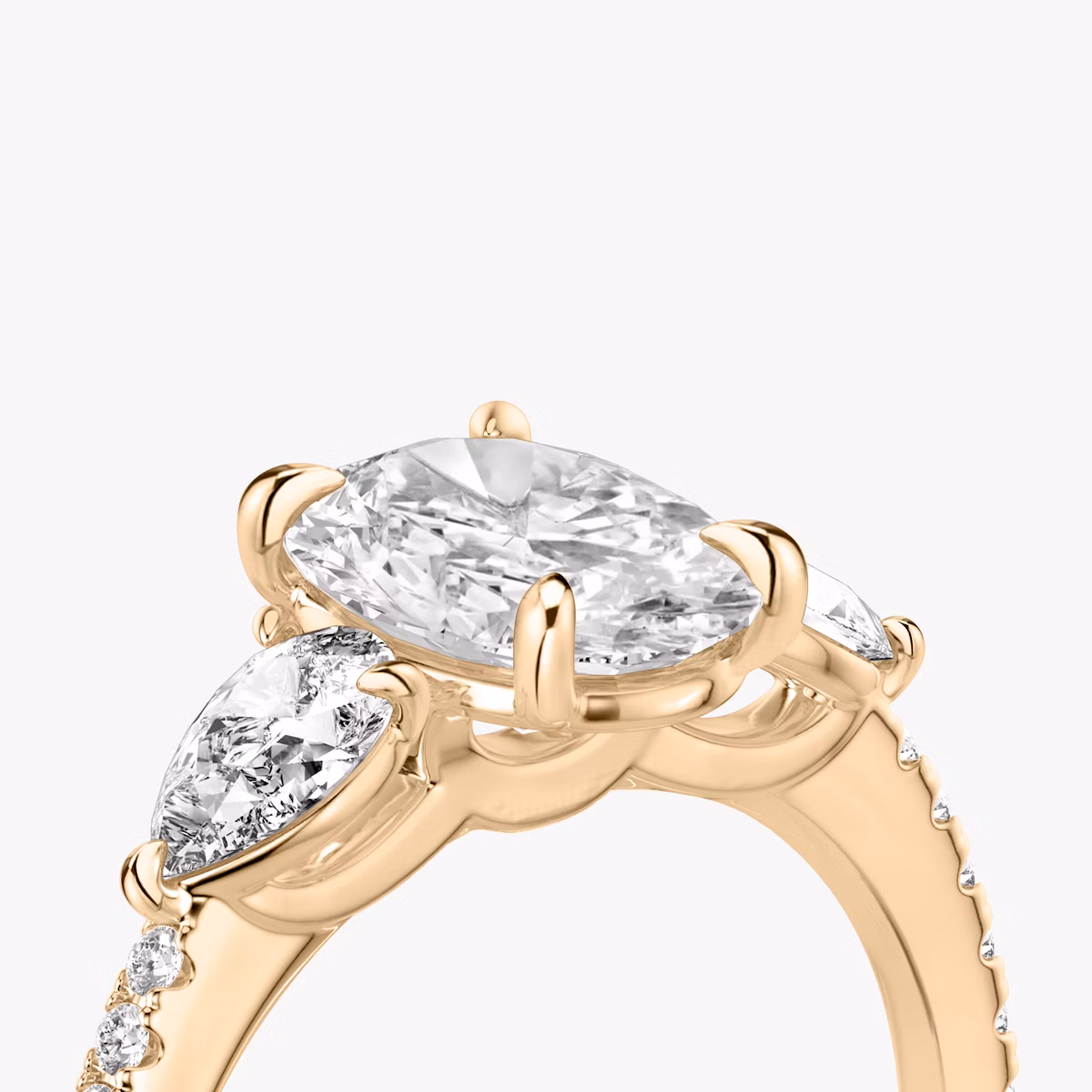 The Three Stone | Oval | 14k | Rose Gold | bandAccent: Pavé | sideStoneCarat: 0.25ct | sideStoneShape: Pear | diamondOrientation: vertical | caratWeight: other