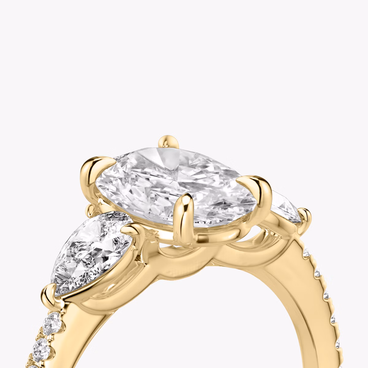 The Three Stone | Oval | 18k | Yellow Gold | bandAccent: Pavé | sideStoneCarat: 0.25ct | sideStoneShape: Pear | diamondOrientation: vertical | caratWeight: other