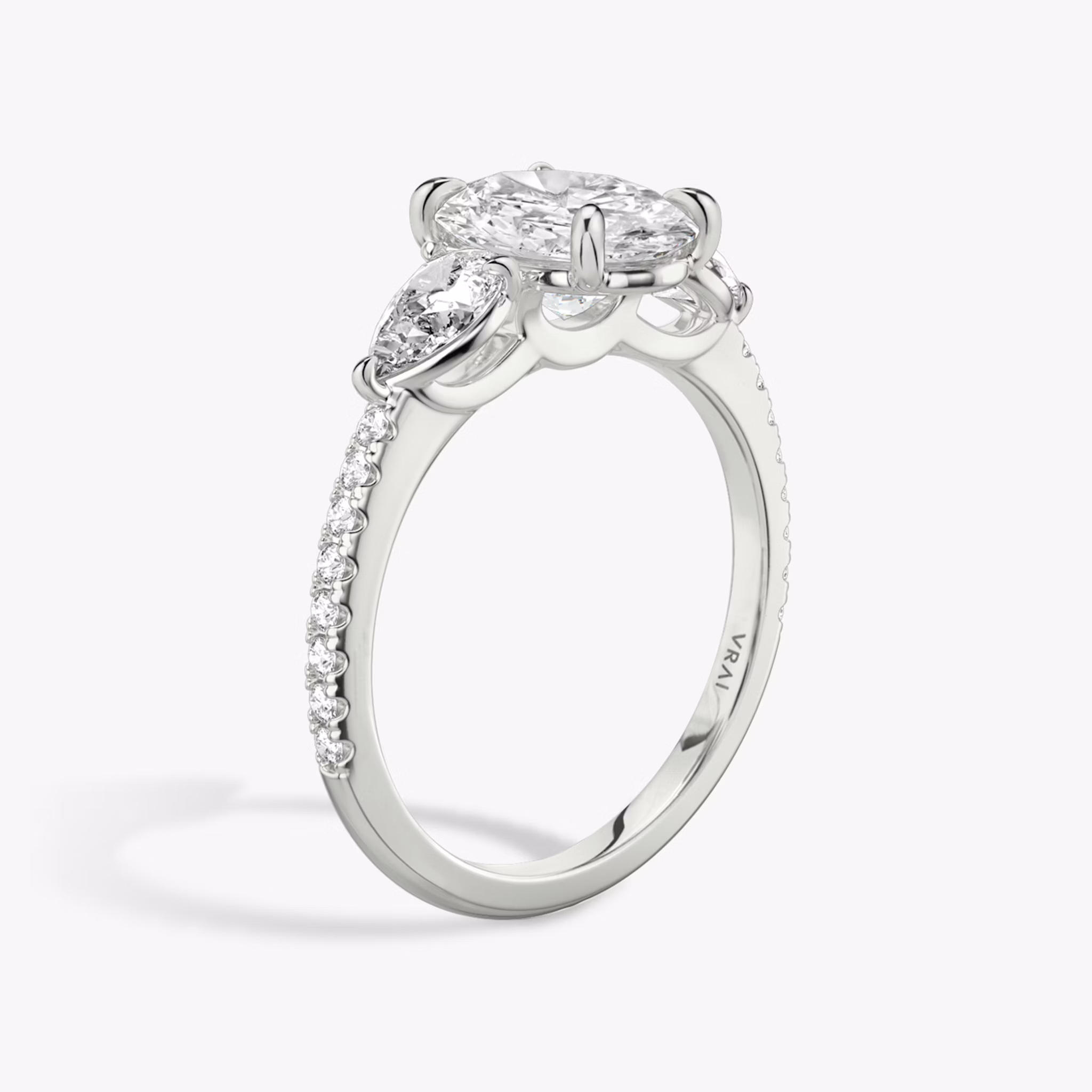 The Three Stone | Oval | 18k | White Gold | bandAccent: Pavé | sideStoneCarat: 0.25ct | sideStoneShape: Pear | diamondOrientation: vertical | caratWeight: other