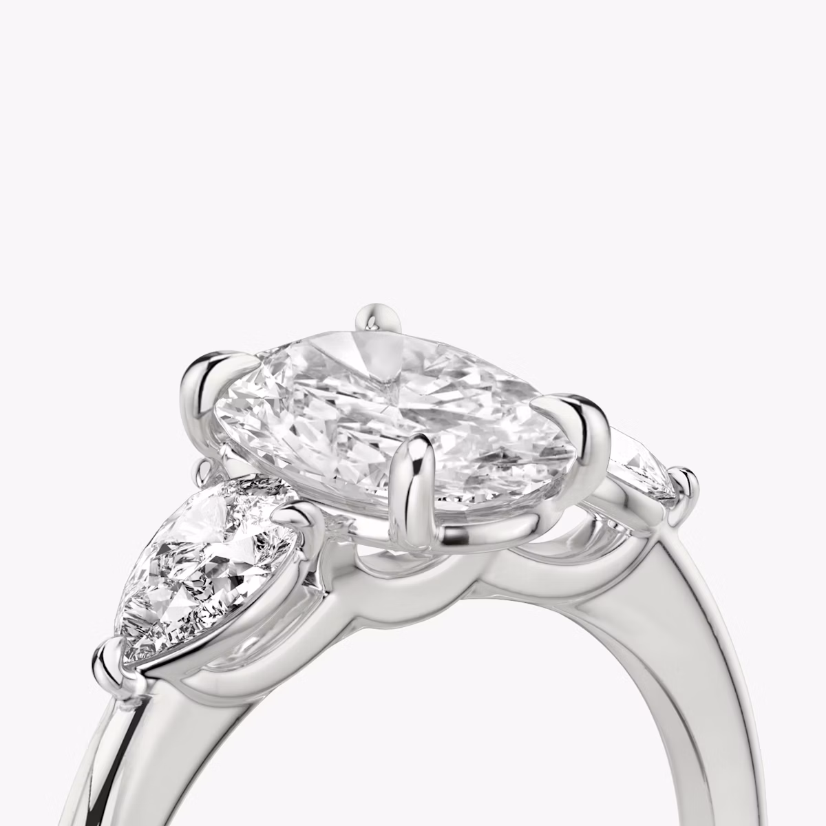 The Three Stone | Oval | Platinum | bandAccent: Plain | sideStoneCarat: 0.25ct | sideStoneShape: Pear | diamondOrientation: vertical | caratWeight: other