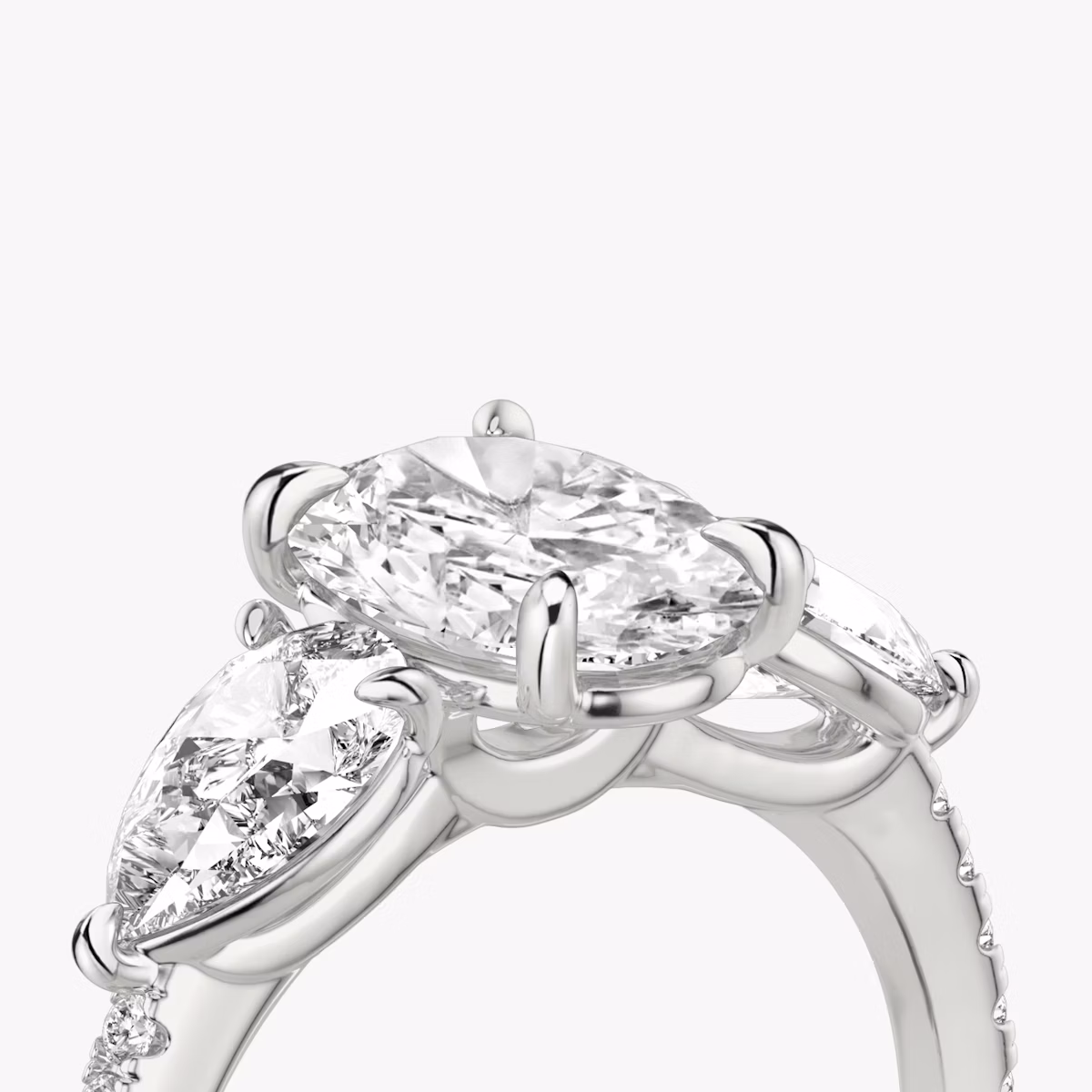 The Three Stone | Oval | Platinum | bandAccent: Pavé | sideStoneCarat: 0.50ct | sideStoneShape: Pear | diamondOrientation: vertical | caratWeight: other