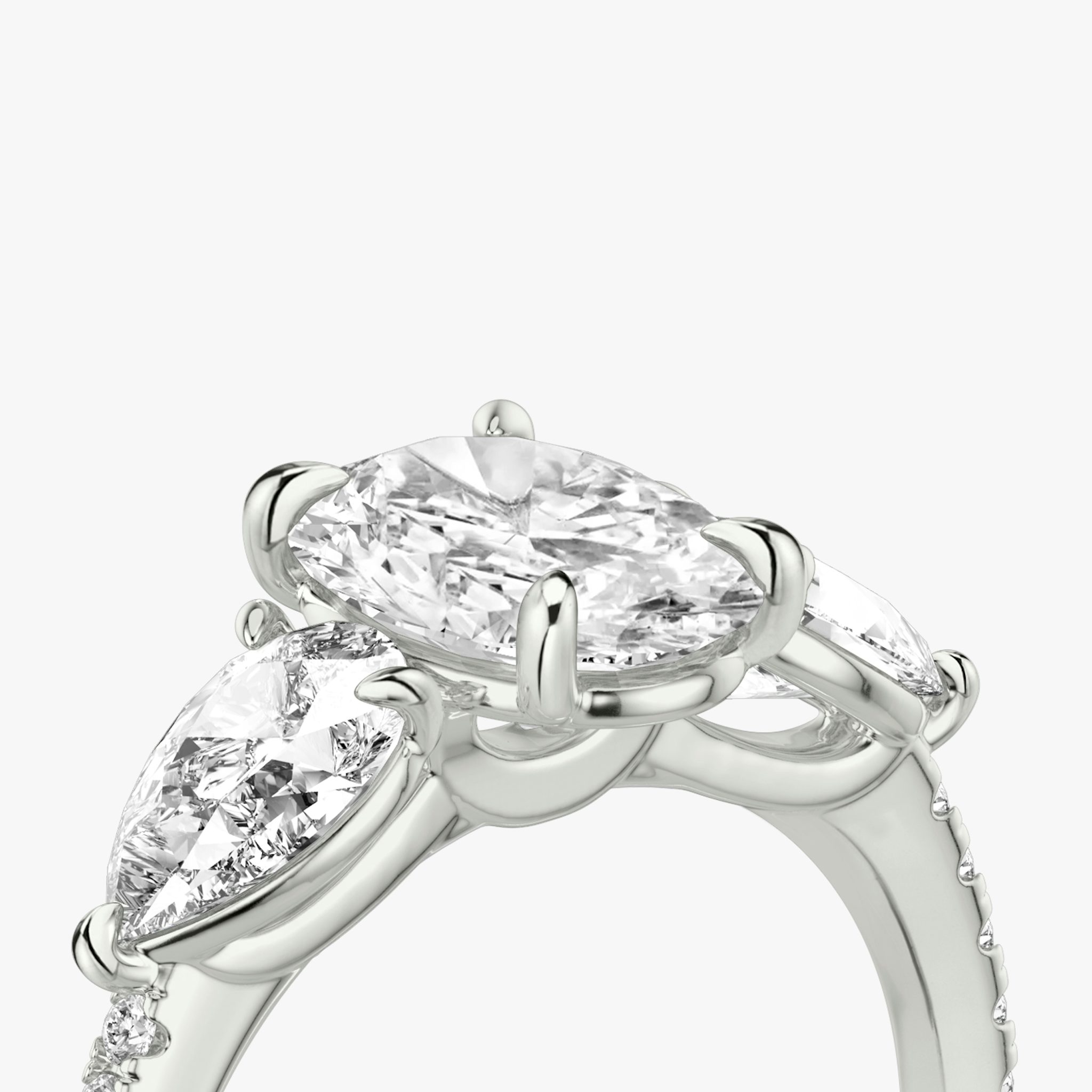 Anillo de compromiso Three Stone | Oval | Platino | bandAccent: Pavé | sideStoneCarat: 0.50ct | sideStoneShape: Pera | diamondOrientation: vertical | caratWeight: other