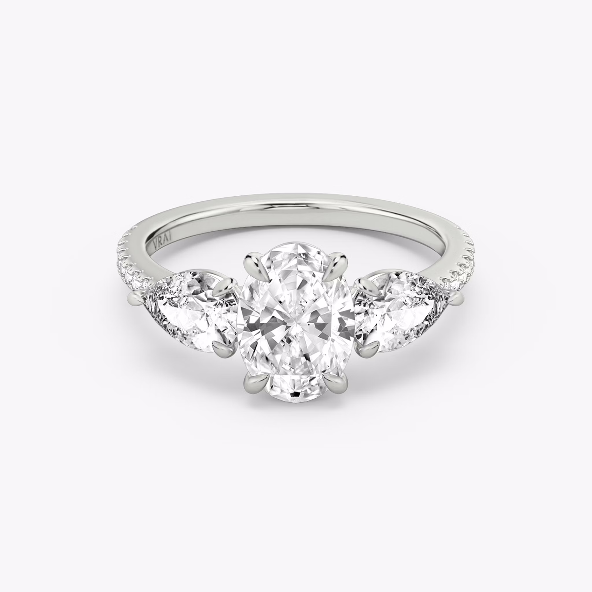 Anillo de compromiso Three Stone | Oval | Platino | bandAccent: Pavé | sideStoneCarat: 0.50ct | sideStoneShape: Pera | diamondOrientation: vertical | caratWeight: other