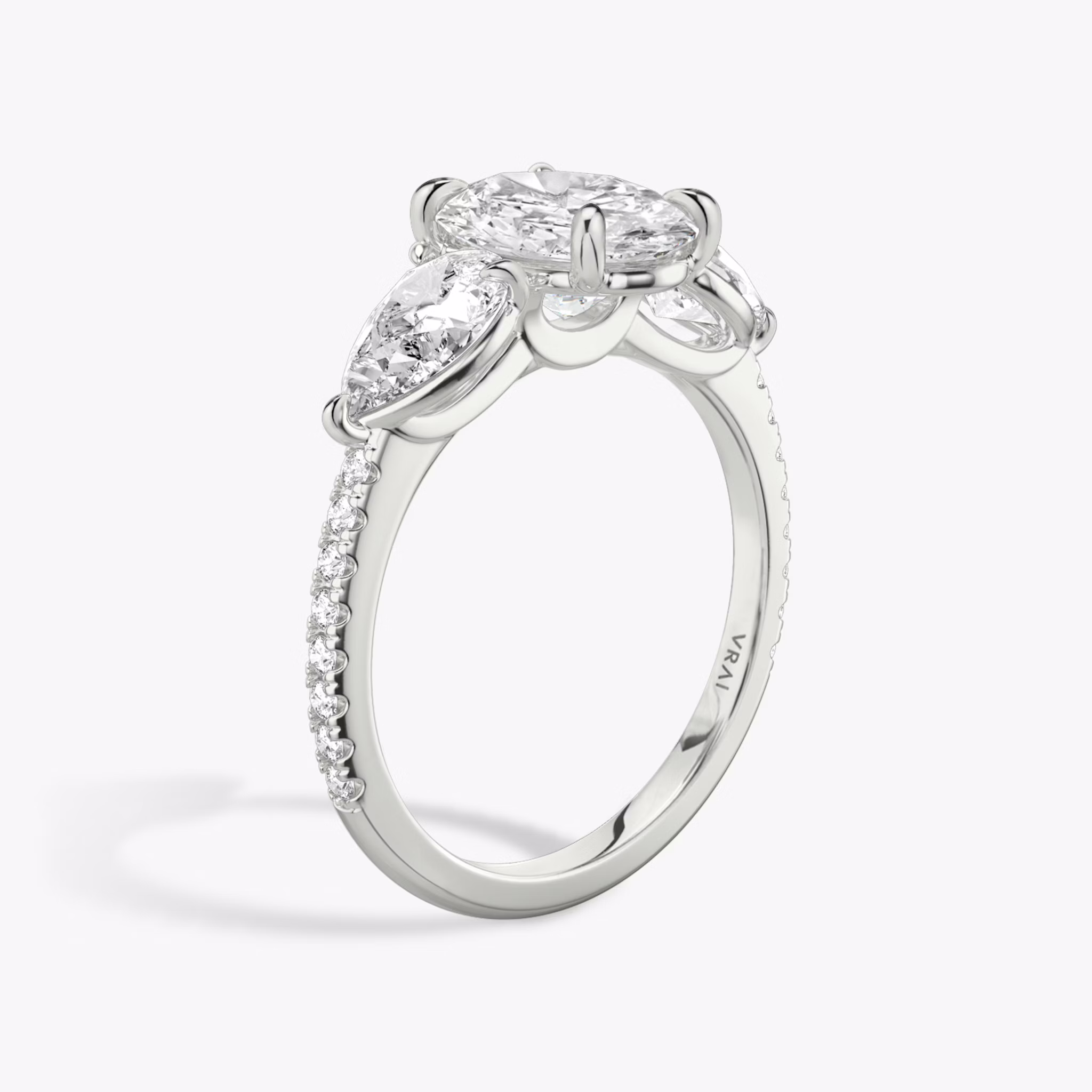 Anillo de compromiso Three Stone | Oval | Platino | bandAccent: Pavé | sideStoneCarat: 0.50ct | sideStoneShape: Pera | diamondOrientation: vertical | caratWeight: other