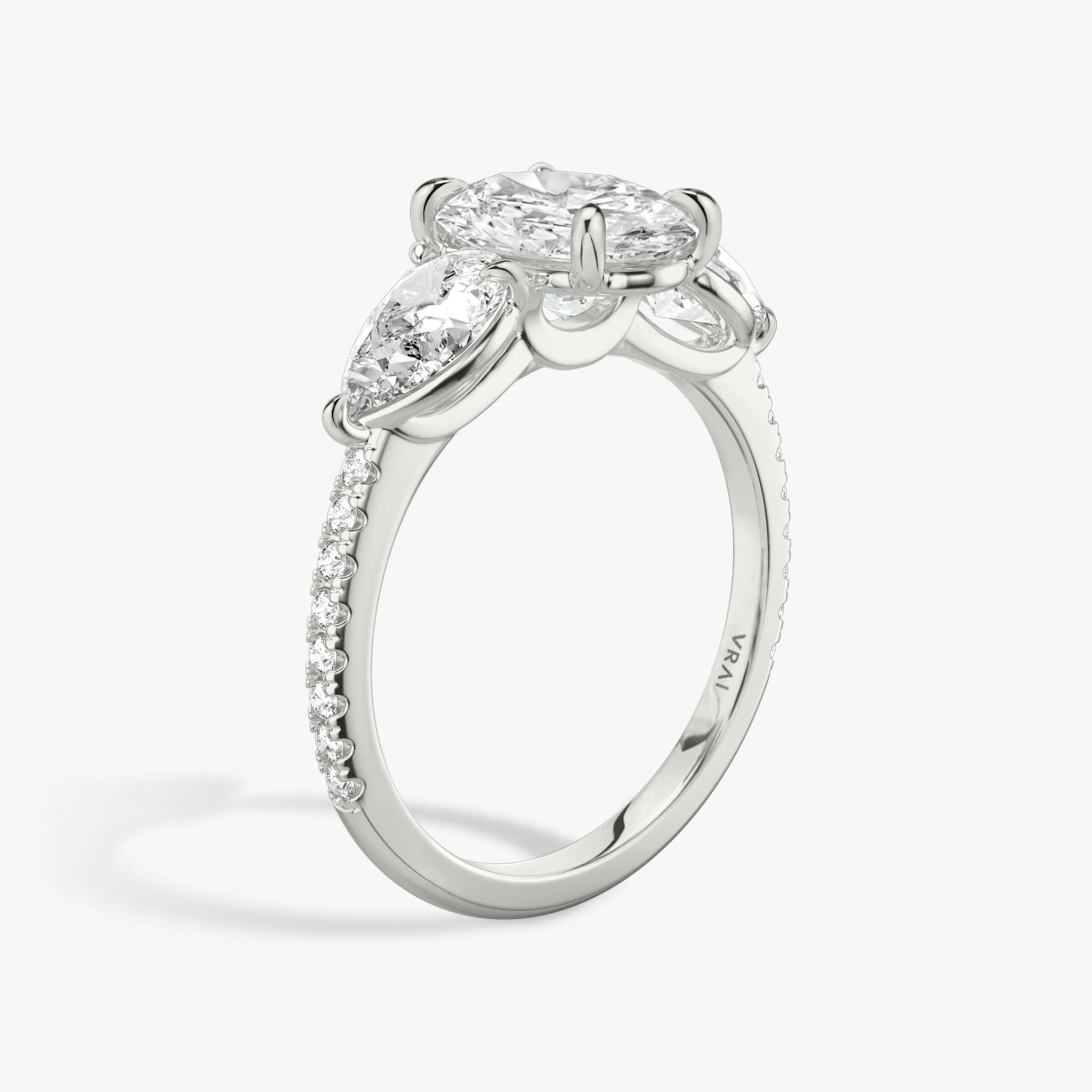 Anillo de compromiso Three Stone | Oval | Platino | bandAccent: Pavé | sideStoneCarat: 0.50ct | sideStoneShape: Pera | diamondOrientation: vertical | caratWeight: other