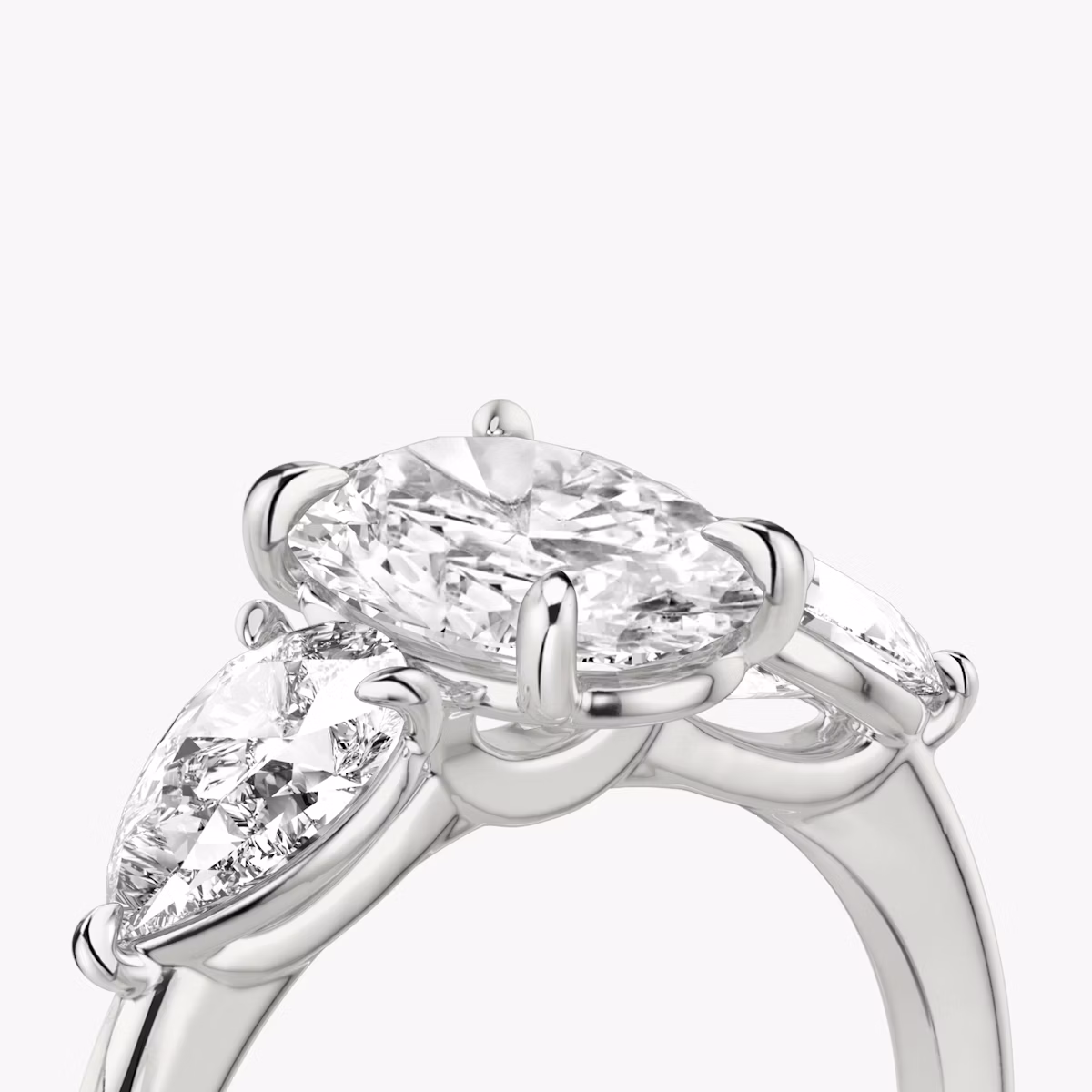 The Three Stone | Oval | Platinum | bandAccent: Plain | sideStoneCarat: 0.50ct | sideStoneShape: Pear | diamondOrientation: vertical | caratWeight: other