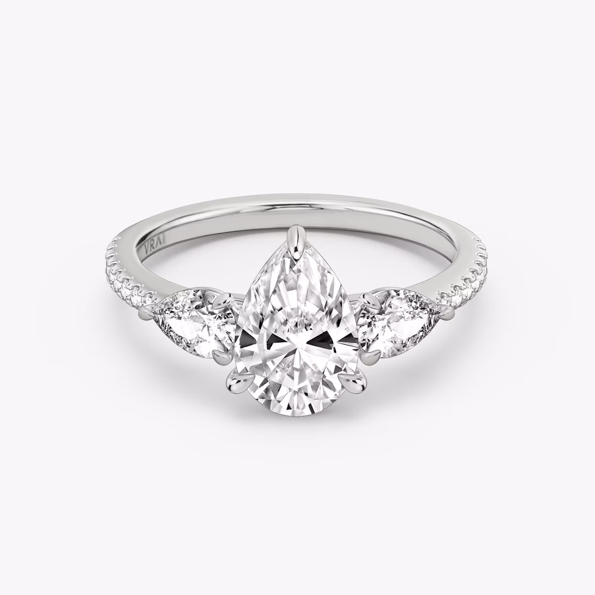 The Three Stone | Pear | 18k | White Gold | bandAccent: Pavé | sideStoneCarat: 0.25ct | sideStoneShape: Pear | diamondOrientation: vertical | caratWeight: other