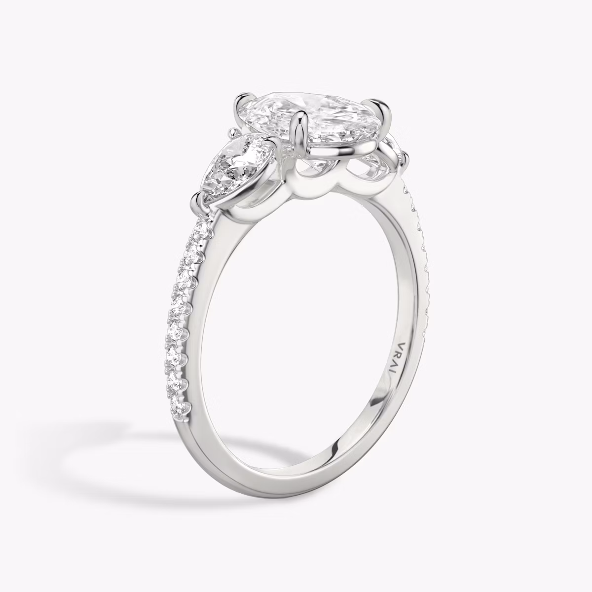 The Three Stone | Pear | 18k | White Gold | bandAccent: Pavé | sideStoneCarat: 0.25ct | sideStoneShape: Pear | diamondOrientation: vertical | caratWeight: other
