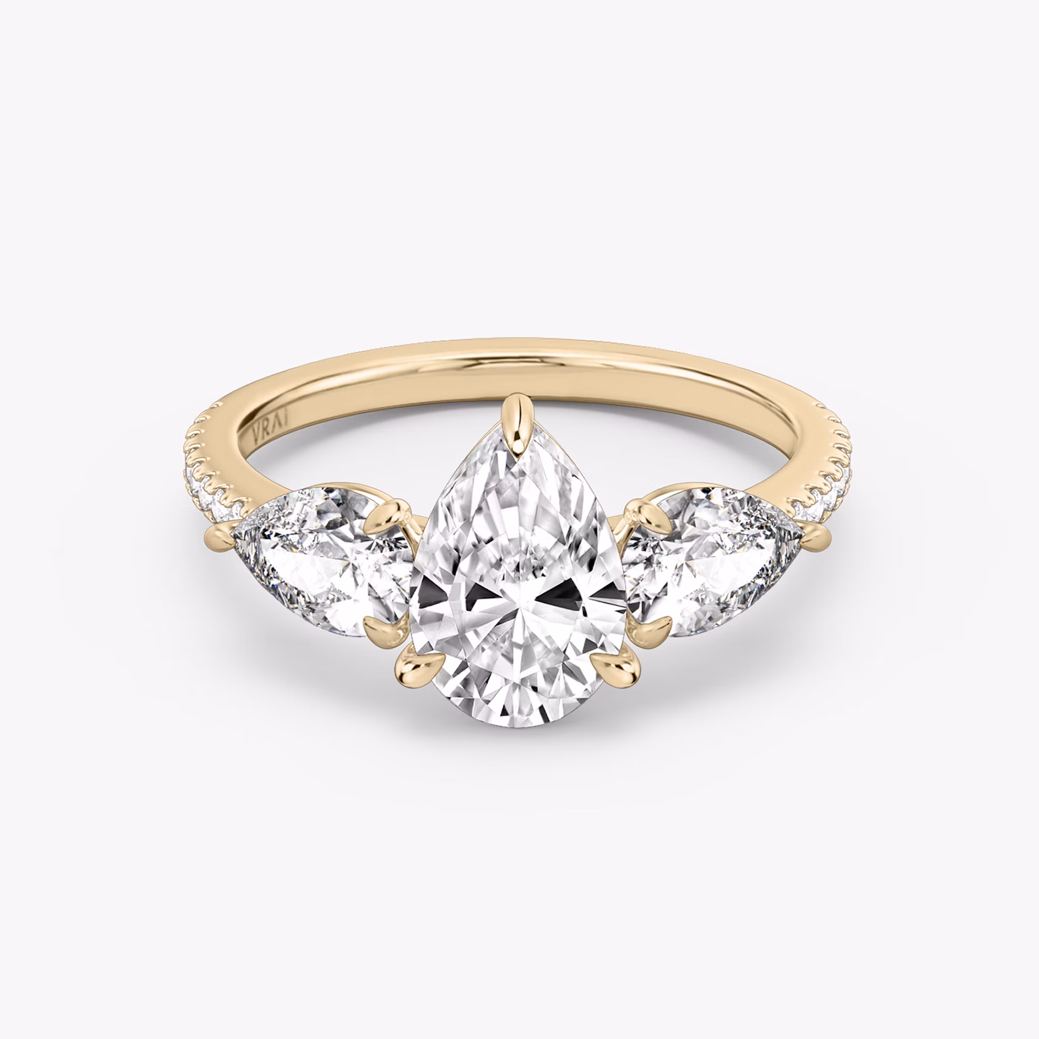Rose gold pavé ring with pear-cut center diamond and two pear side stones, shown on white background.