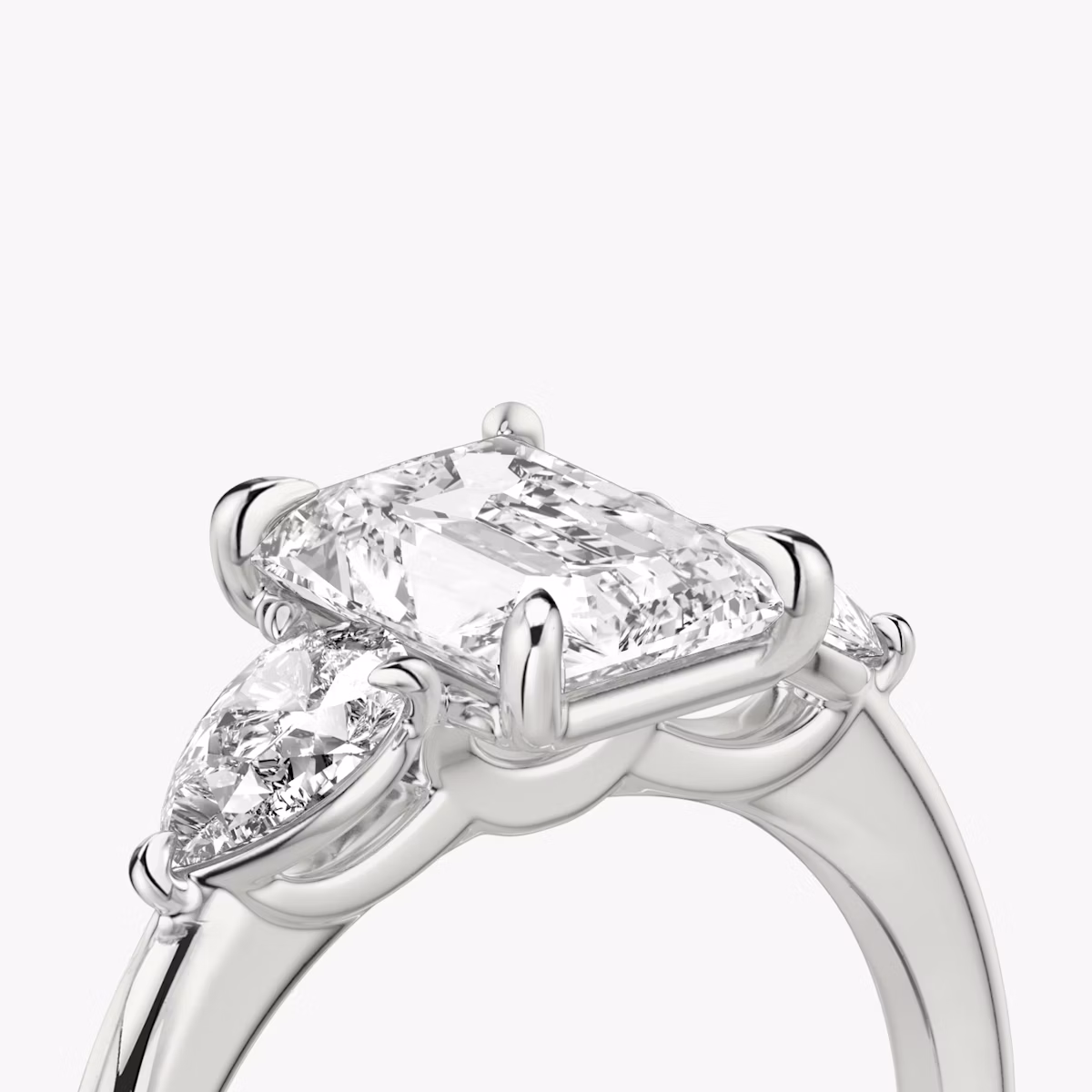 The Three Stone | Radiant | Platinum | bandAccent: Plain | sideStoneCarat: 0.25ct | sideStoneShape: Pear | diamondOrientation: vertical | caratWeight: other