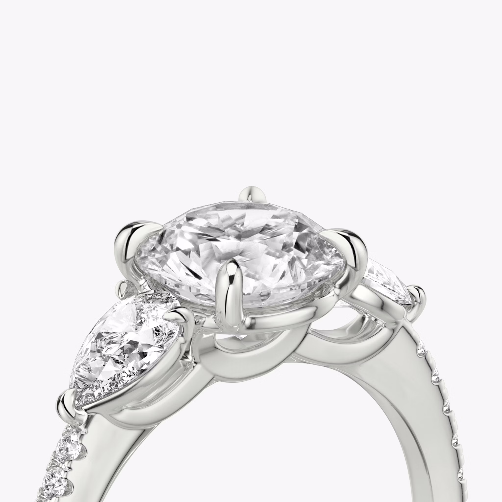 The Three Stone | Round Brilliant | Platinum | bandAccent: Pavé | caratWeight: other | sideStoneCarat: 0.25ct | sideStoneShape: Pear | diamondOrientation: vertical