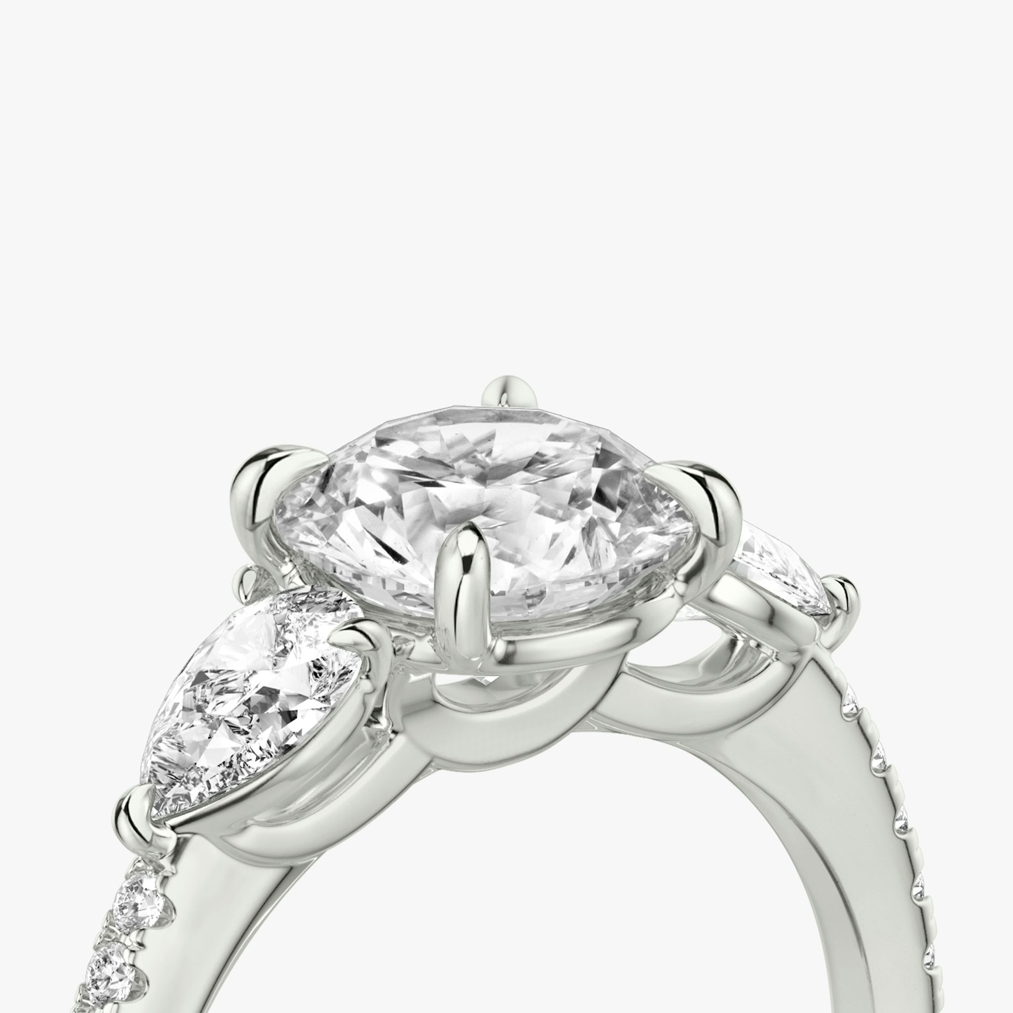 The Three Stone | Round Brilliant | Platinum | bandAccent: Pavé | caratWeight: other | sideStoneCarat: 0.25ct | sideStoneShape: Pear | diamondOrientation: vertical