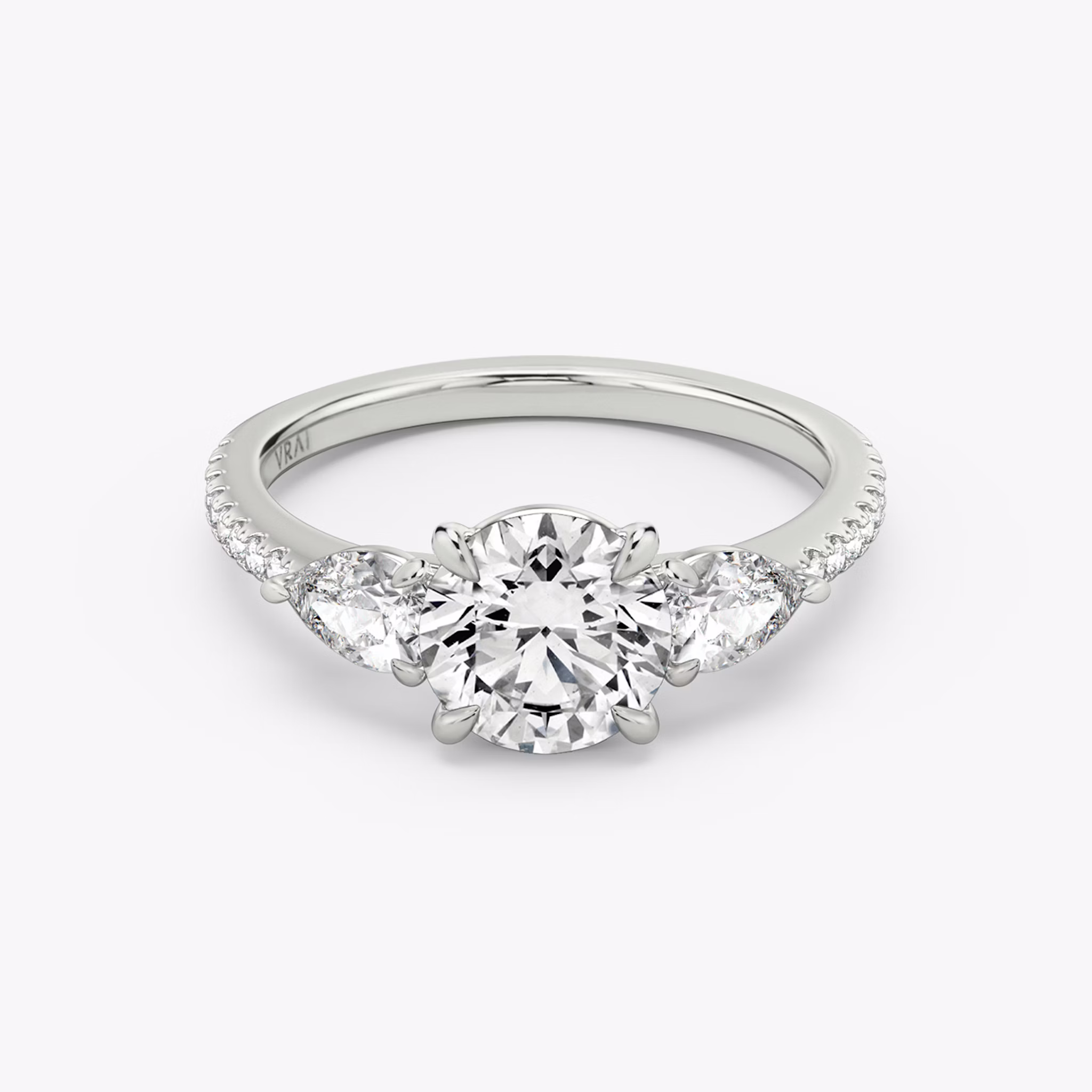 The Three Stone | Round Brilliant | Platinum | bandAccent: Pavé | caratWeight: other | sideStoneCarat: 0.25ct | sideStoneShape: Pear | diamondOrientation: vertical