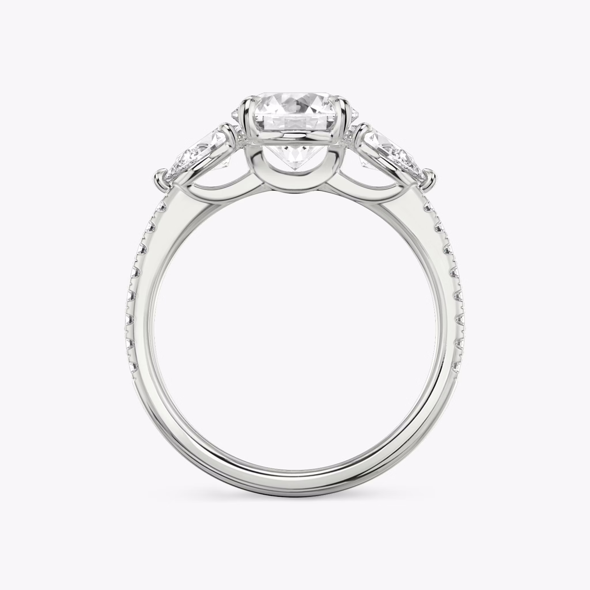 The Three Stone | Round Brilliant | Platinum | bandAccent: Pavé | caratWeight: other | sideStoneCarat: 0.25ct | sideStoneShape: Pear | diamondOrientation: vertical