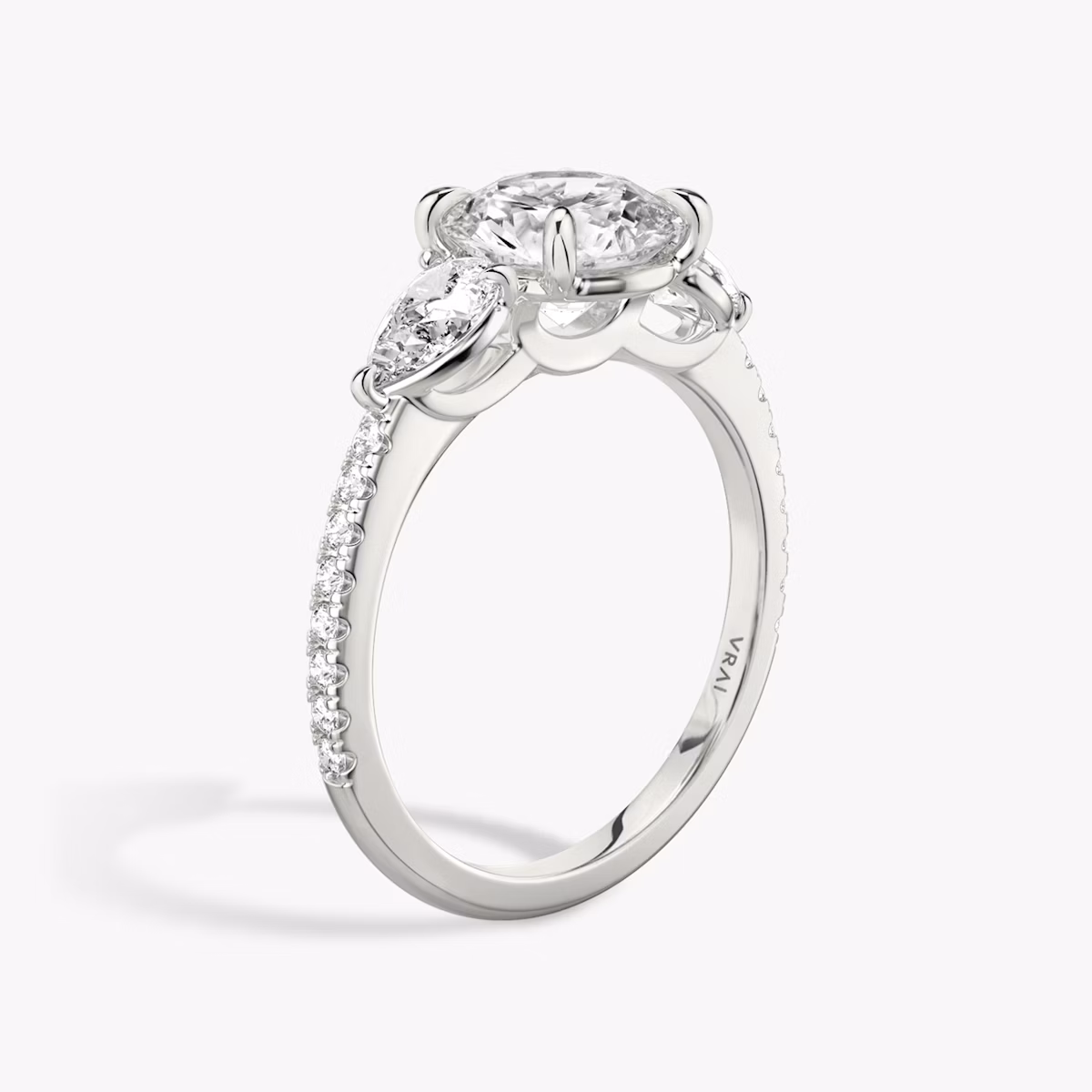 The Three Stone | Round Brilliant | 18k | White Gold | bandAccent: Pavé | caratWeight: other | sideStoneCarat: 0.25ct | sideStoneShape: Pear | diamondOrientation: vertical