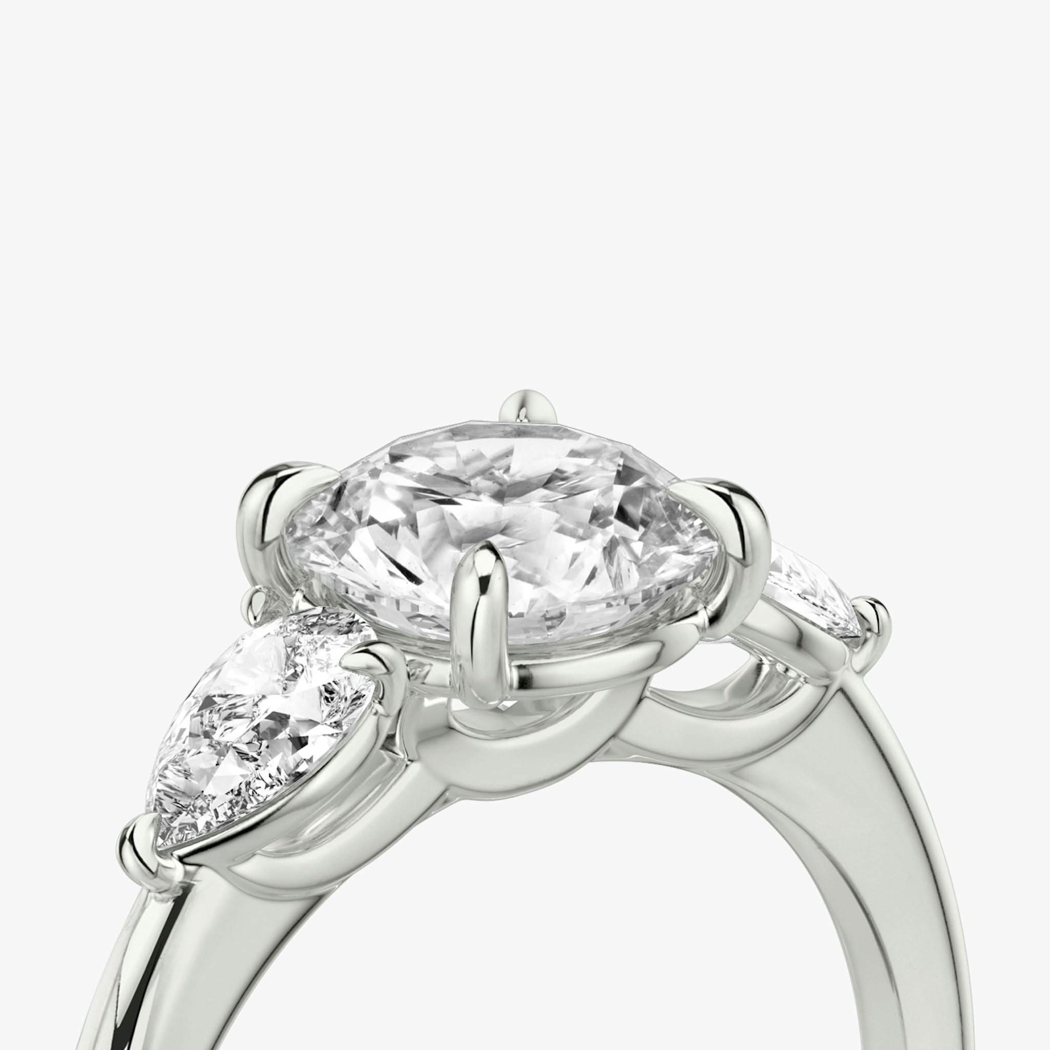 The Three Stone | Round Brilliant | Platinum | bandAccent: Plain | caratWeight: other | sideStoneCarat: 0.25ct | sideStoneShape: Pear | diamondOrientation: vertical