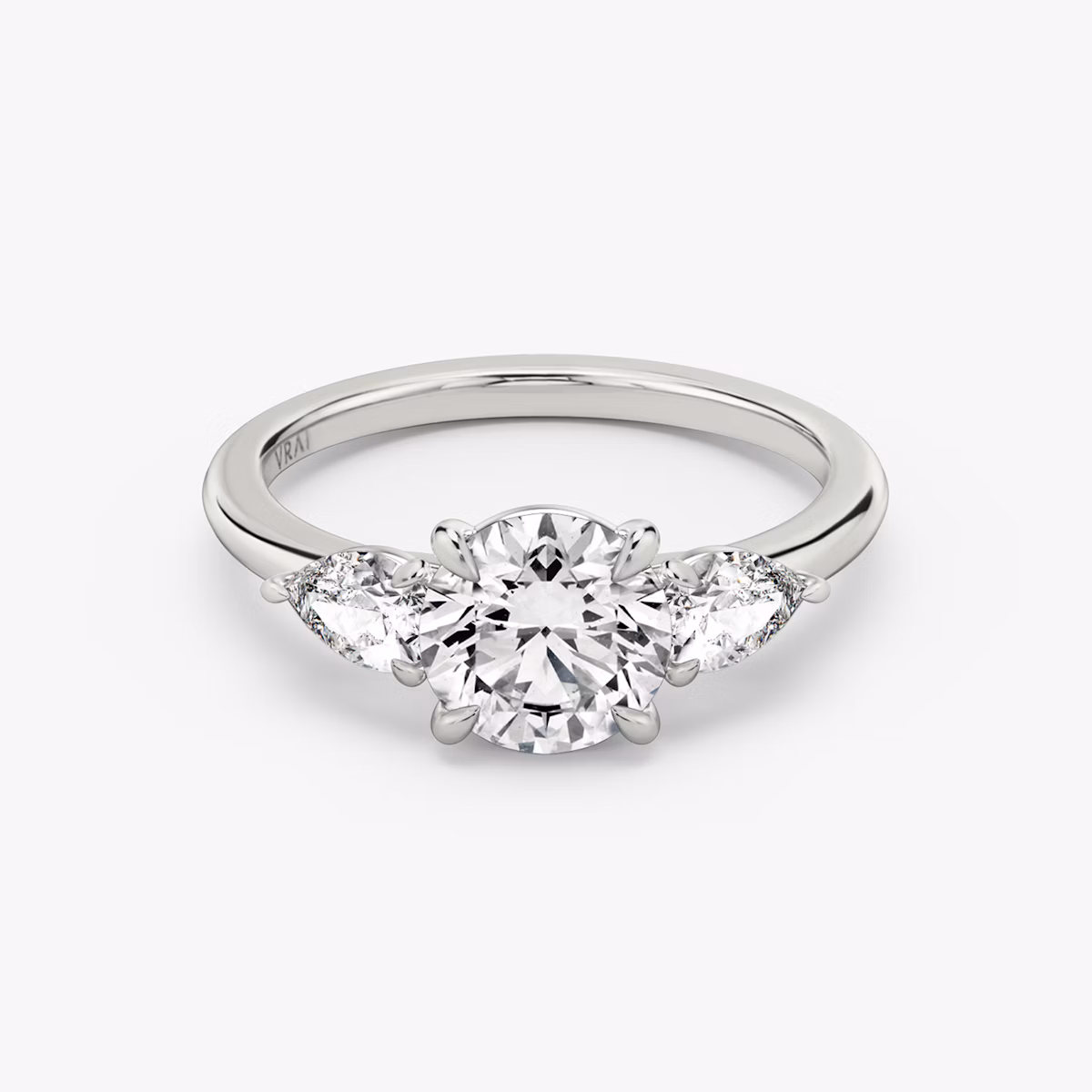 The Three Stone | Round Brilliant | Platinum | bandAccent: Plain | caratWeight: other | sideStoneCarat: 0.25ct | sideStoneShape: Pear | diamondOrientation: vertical