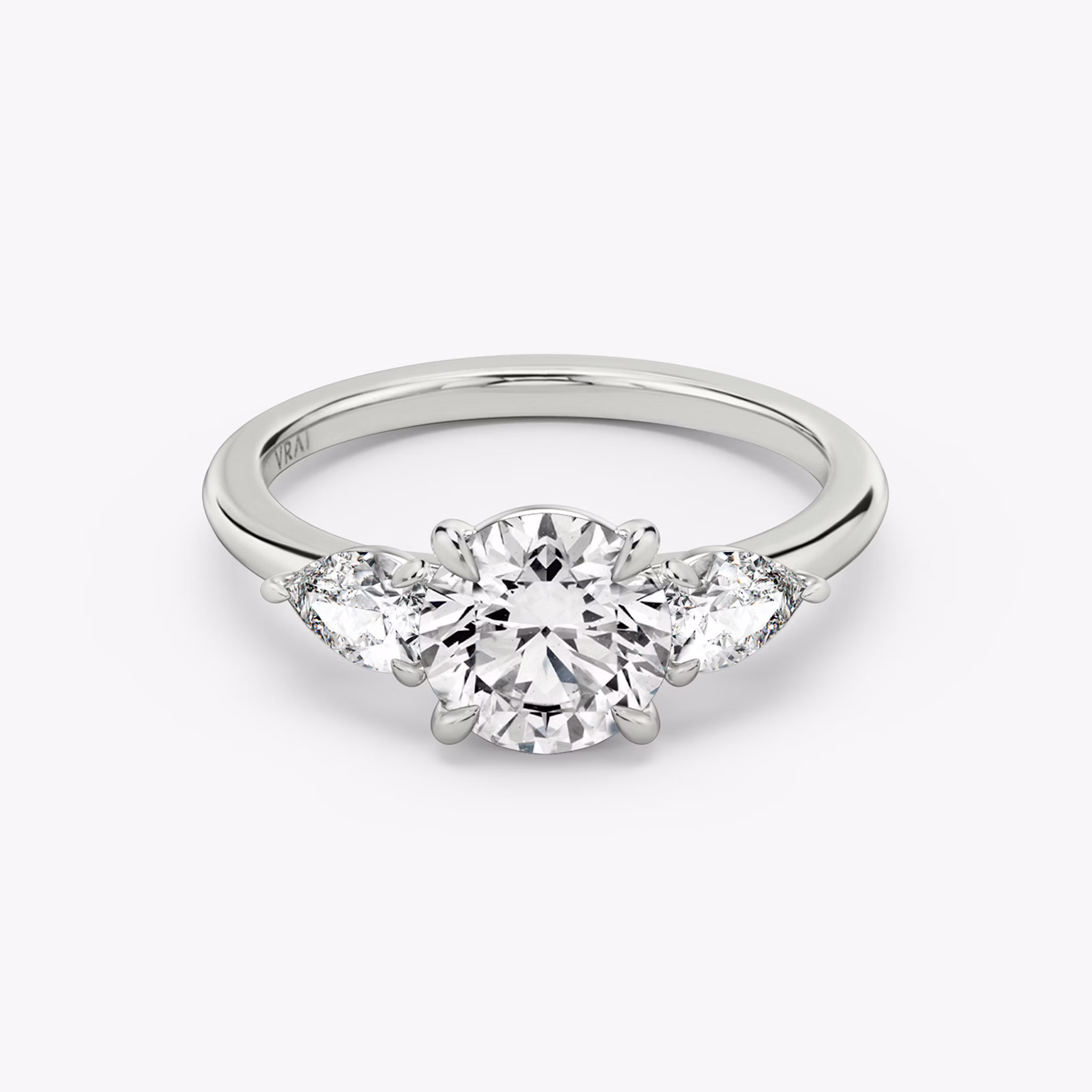 The Three Stone | Round Brilliant | Platinum | bandAccent: Plain | caratWeight: other | sideStoneCarat: 0.25ct | sideStoneShape: Pear | diamondOrientation: vertical
