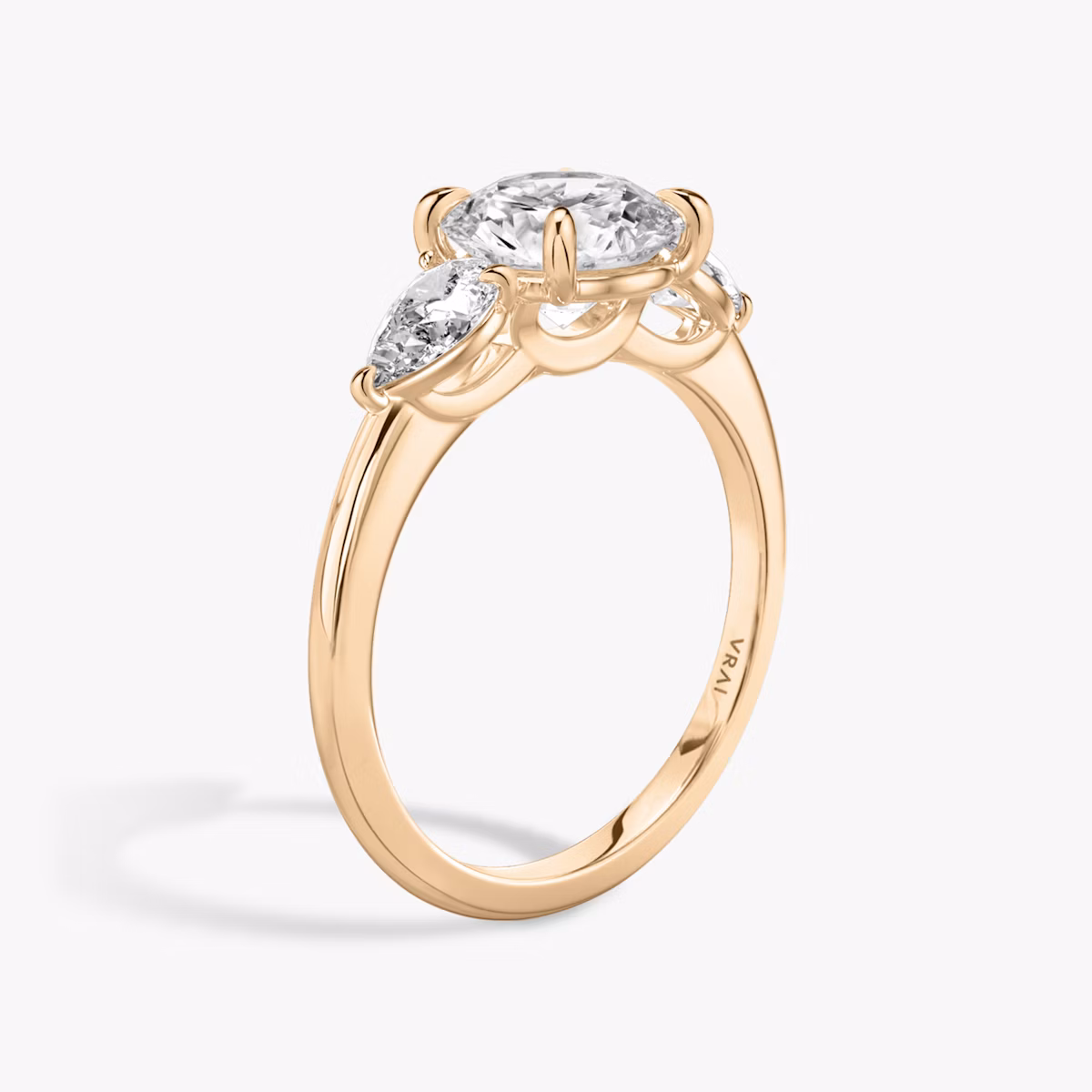 The Three Stone | Round Brilliant | 14k | Rose Gold | bandAccent: Plain | caratWeight: other | sideStoneCarat: 0.25ct | sideStoneShape: Pear | diamondOrientation: vertical