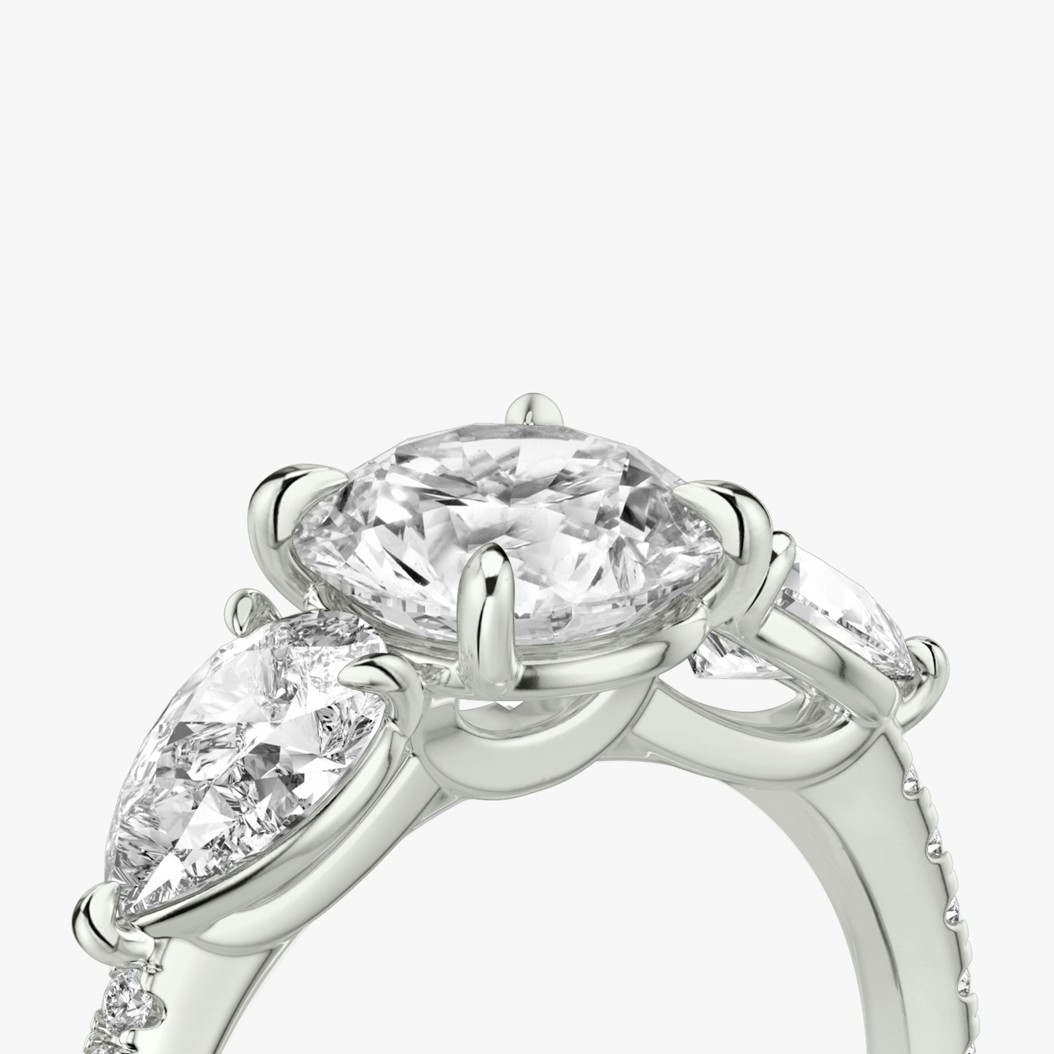 The Three Stone | Round Brilliant | Platinum | bandAccent: Pavé | caratWeight: other | sideStoneCarat: 0.50ct | sideStoneShape: Pear | diamondOrientation: vertical