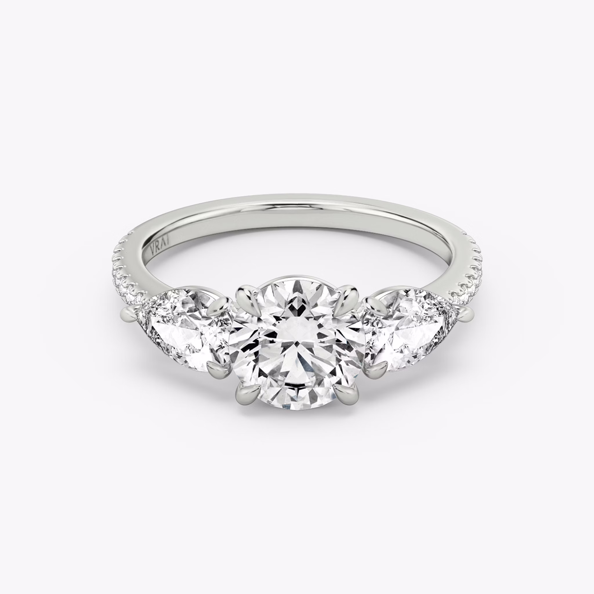 The Three Stone | Round Brilliant | Platinum | bandAccent: Pavé | caratWeight: other | sideStoneCarat: 0.50ct | sideStoneShape: Pear | diamondOrientation: vertical