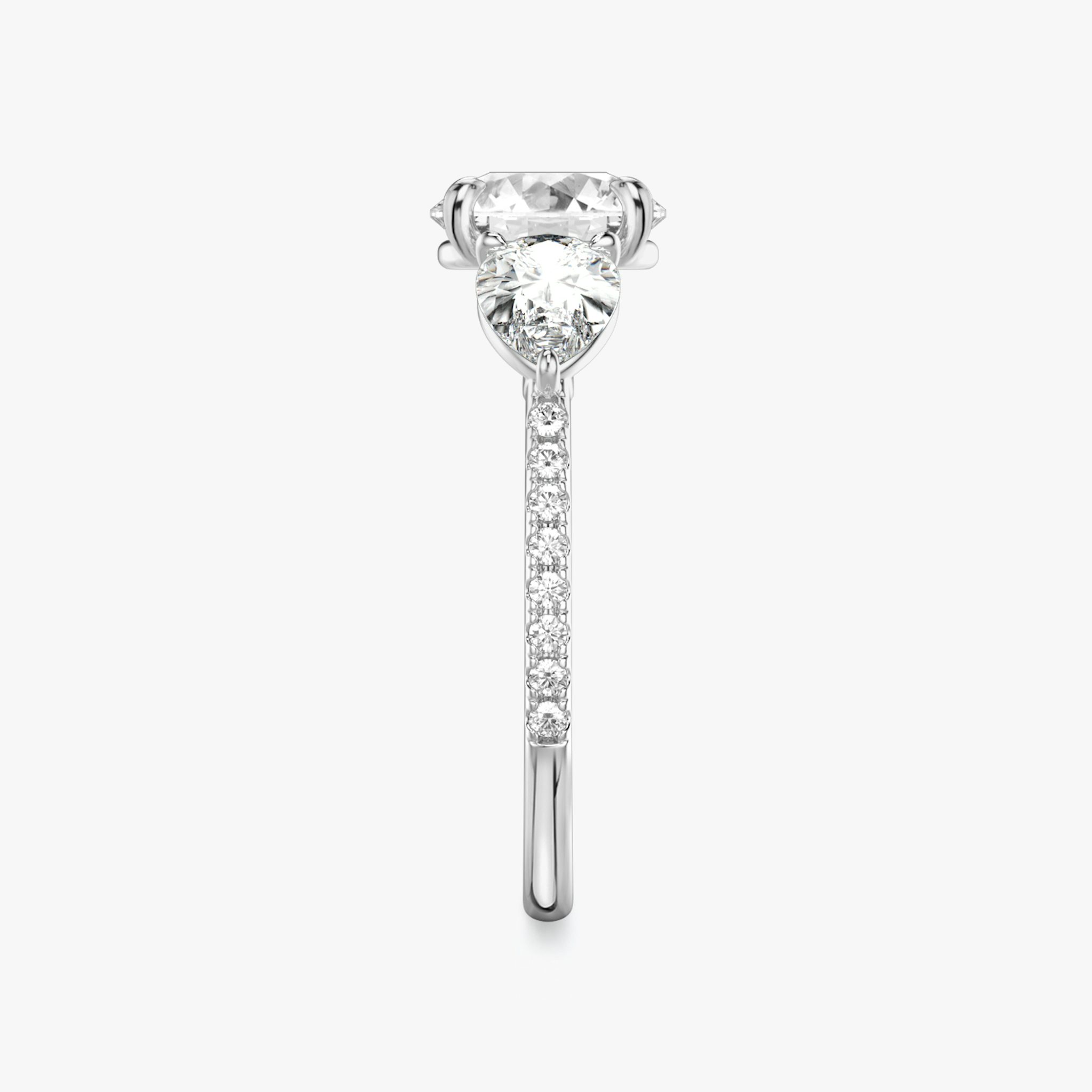 The Three Stone | Round Brilliant | Platinum | bandAccent: Pavé | caratWeight: other | sideStoneCarat: 0.50ct | sideStoneShape: Pear | diamondOrientation: vertical