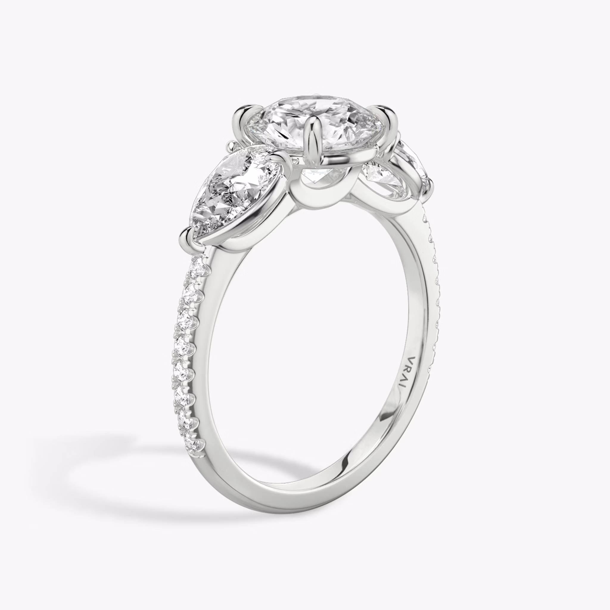 The Three Stone | Round Brilliant | Platinum | bandAccent: Pavé | caratWeight: other | sideStoneCarat: 0.50ct | sideStoneShape: Pear | diamondOrientation: vertical